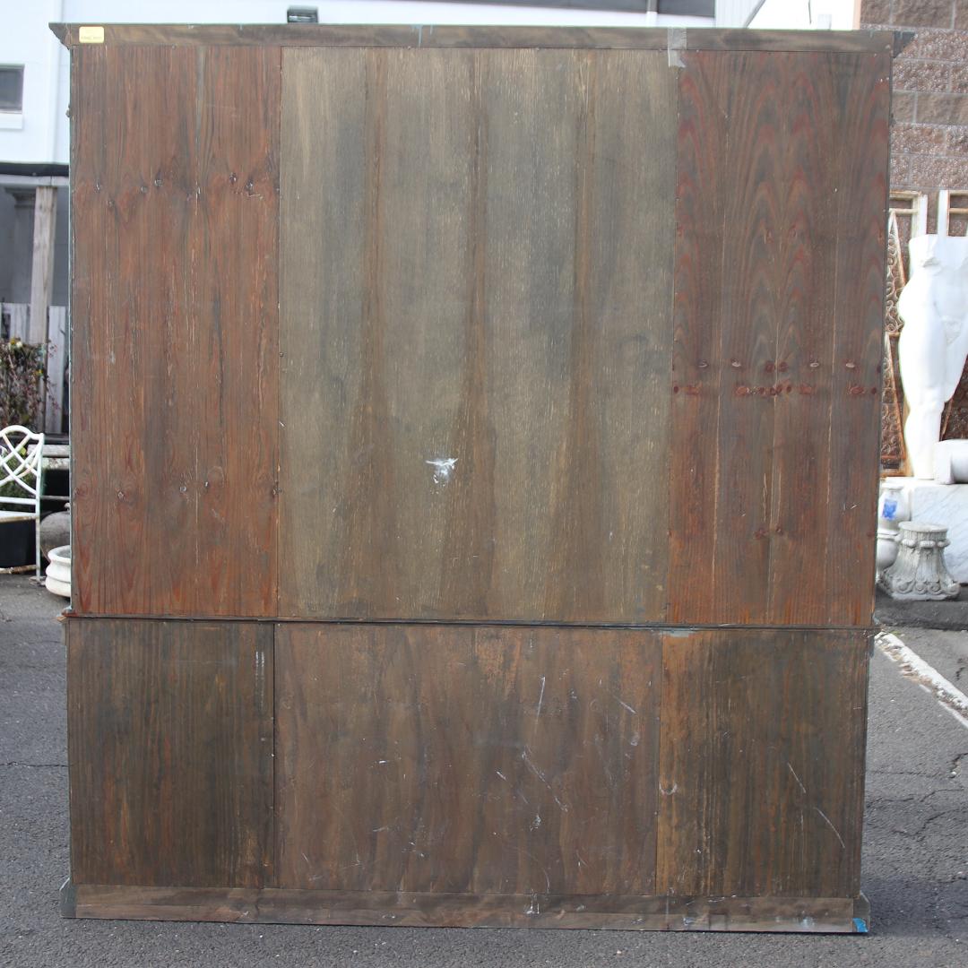Painted and decorated breakfront cabinet by William Switzer with beaded glass doors. The piece also features gold painted neoclassical details such as fluted trim framing the glass cabinets, Roman swags and urns on the pediment, and carved foliage