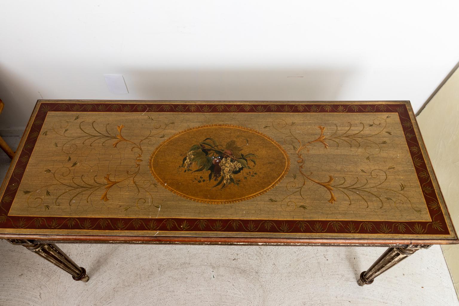 Italian style console table with fluted, turned legs on arrow feet. The table is also ornamented with a band of pierced disk trim on the apron and a tabletop painted with foliage and a center medallion of grapes. Please note of wear consistent with