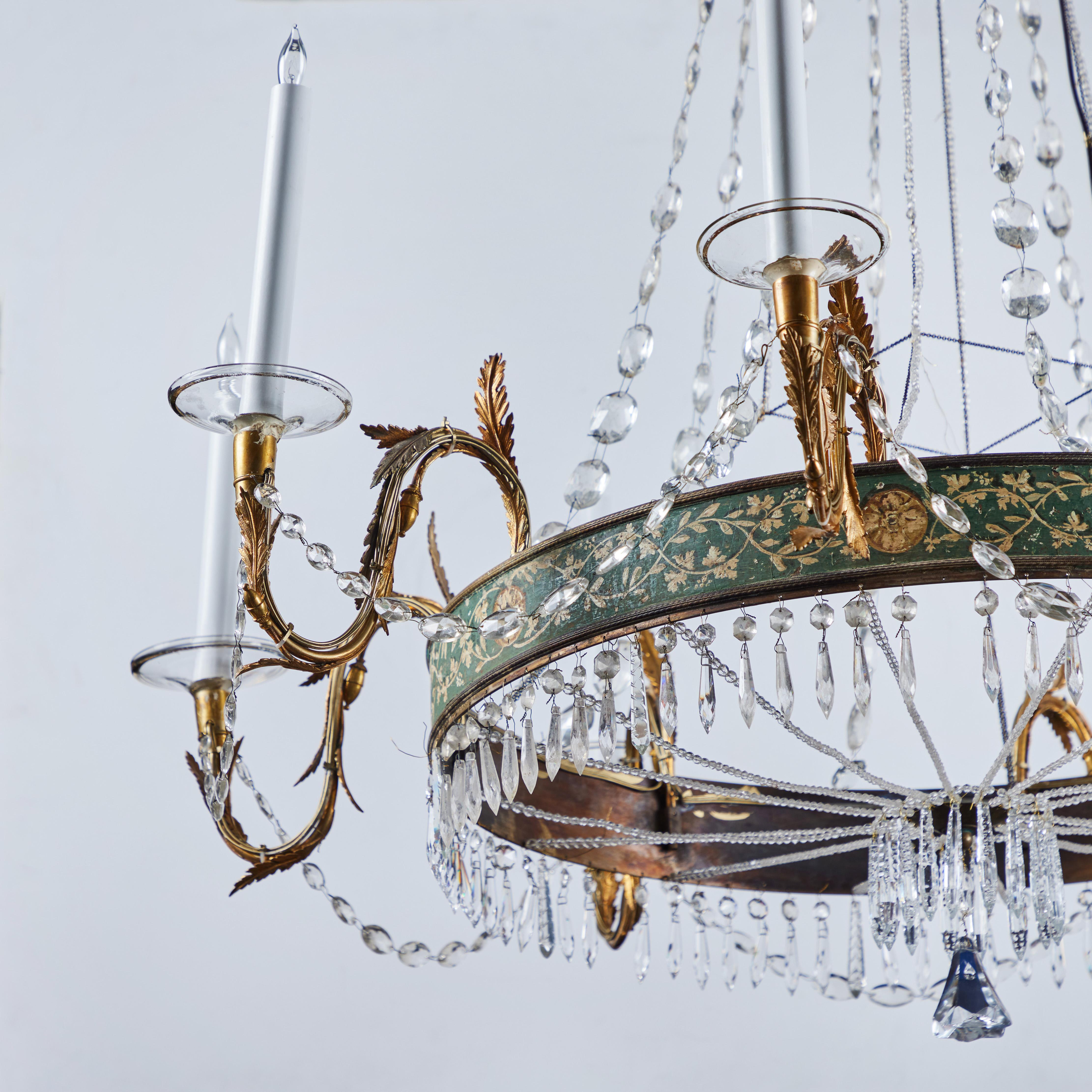 A beautiful crystal chandelier with hand painted bronze ring with foliate and flora designs supporting the elegant 8 gilded bronze arms also with  foliate and flora design, which terminate with glass bobeches supporting the 8 lights.  