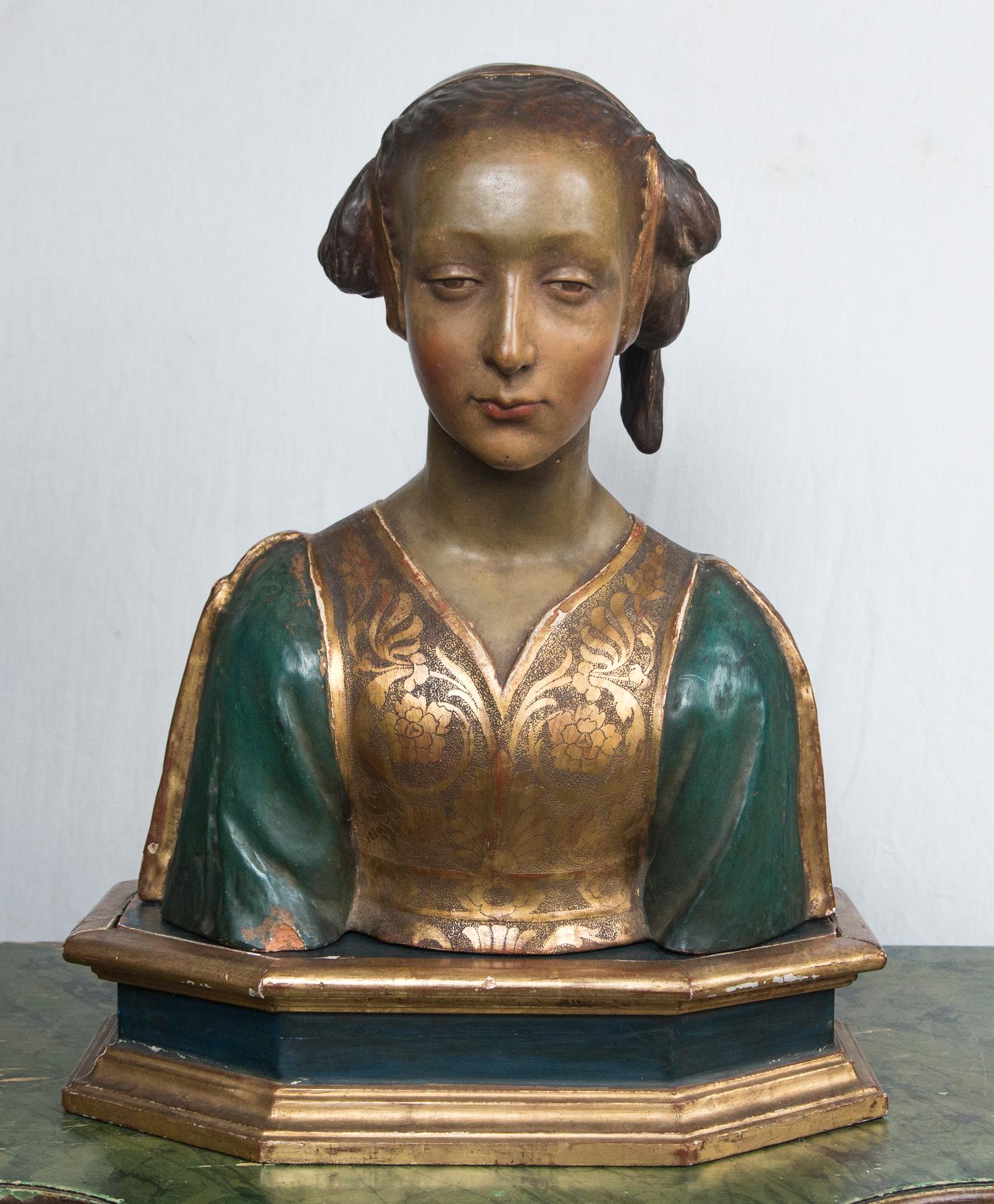 Painted in naturalistic colors. Wearing a gilded and green garment. Her hair gathered to the left side of her head with a golden ribbon.
She sits upon a separate hand made 8 sided wooden base. it is painted black with gold moldings. In pencil, on