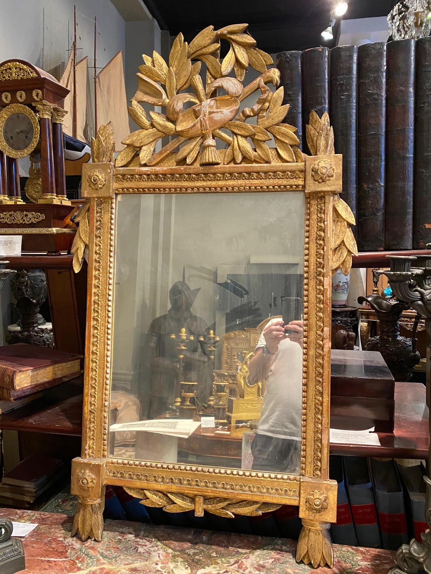Specchio in legno dipinto e dorato di epoca Luigi XVI con parte superiore decorata a colomba e contorno di foglie di alloro.