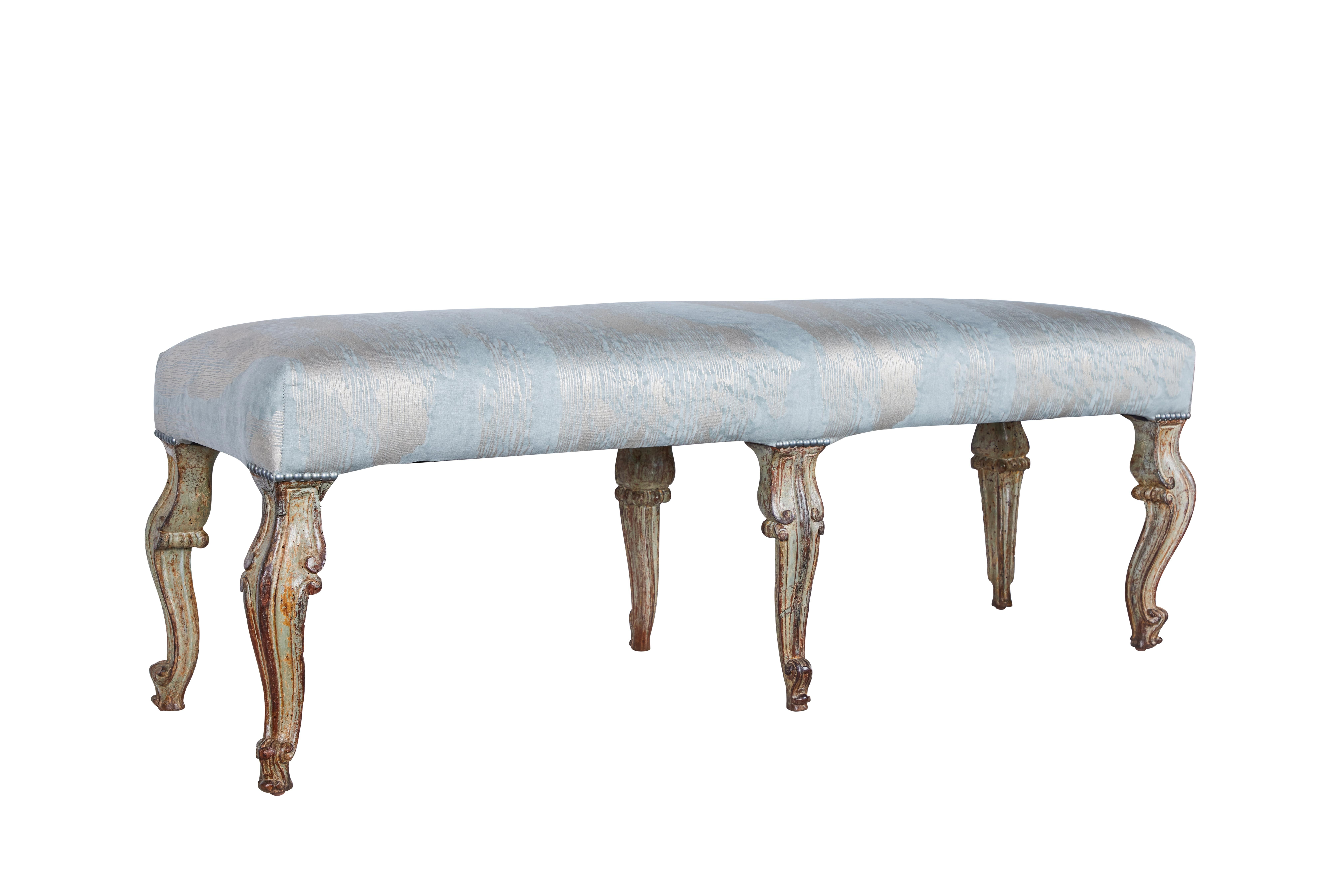 A beautifully hand carved painted and parcel gilt bench, from the Piedmont District of Italy. New Fortuny upholstery.