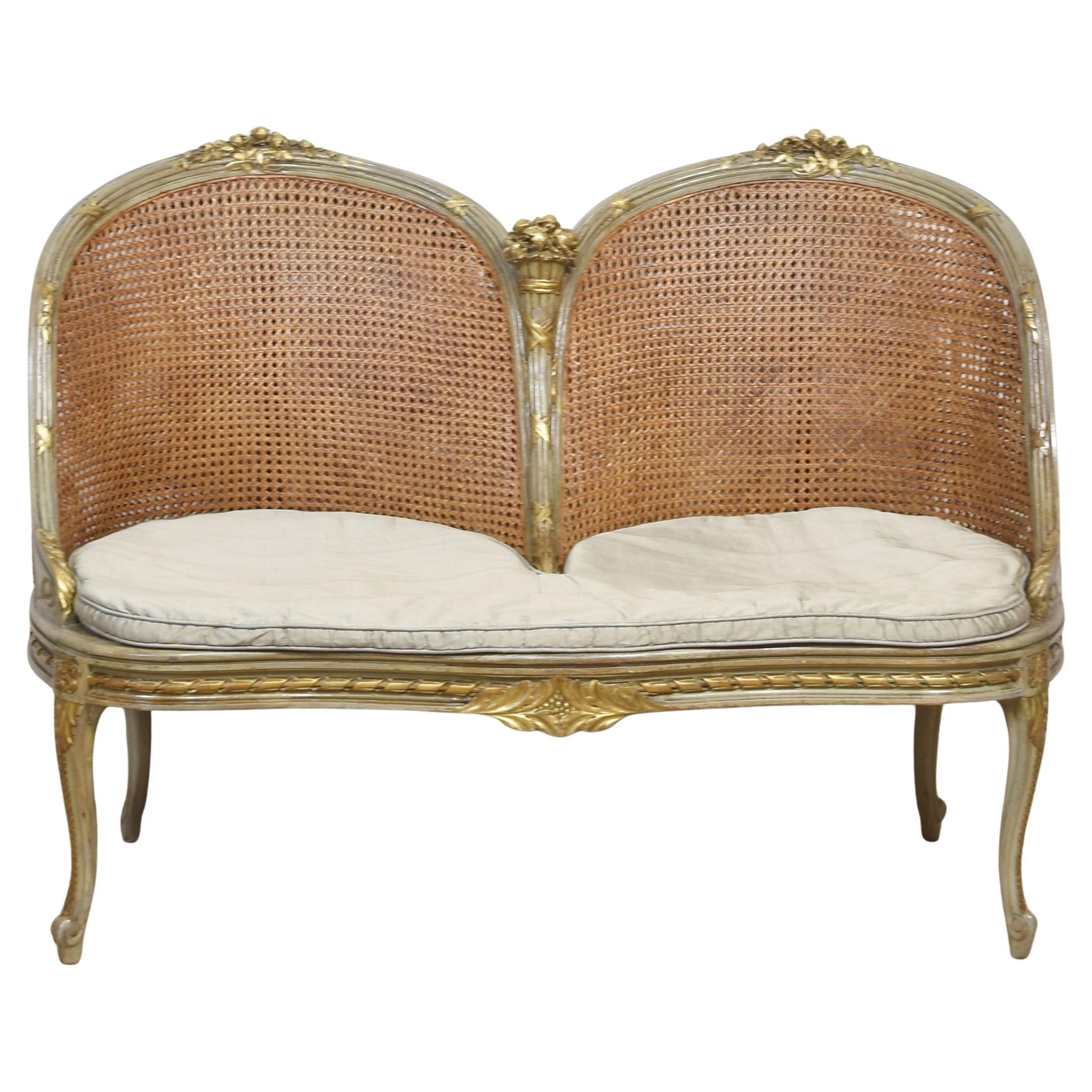 Painted and parcel gilt caned canape settee