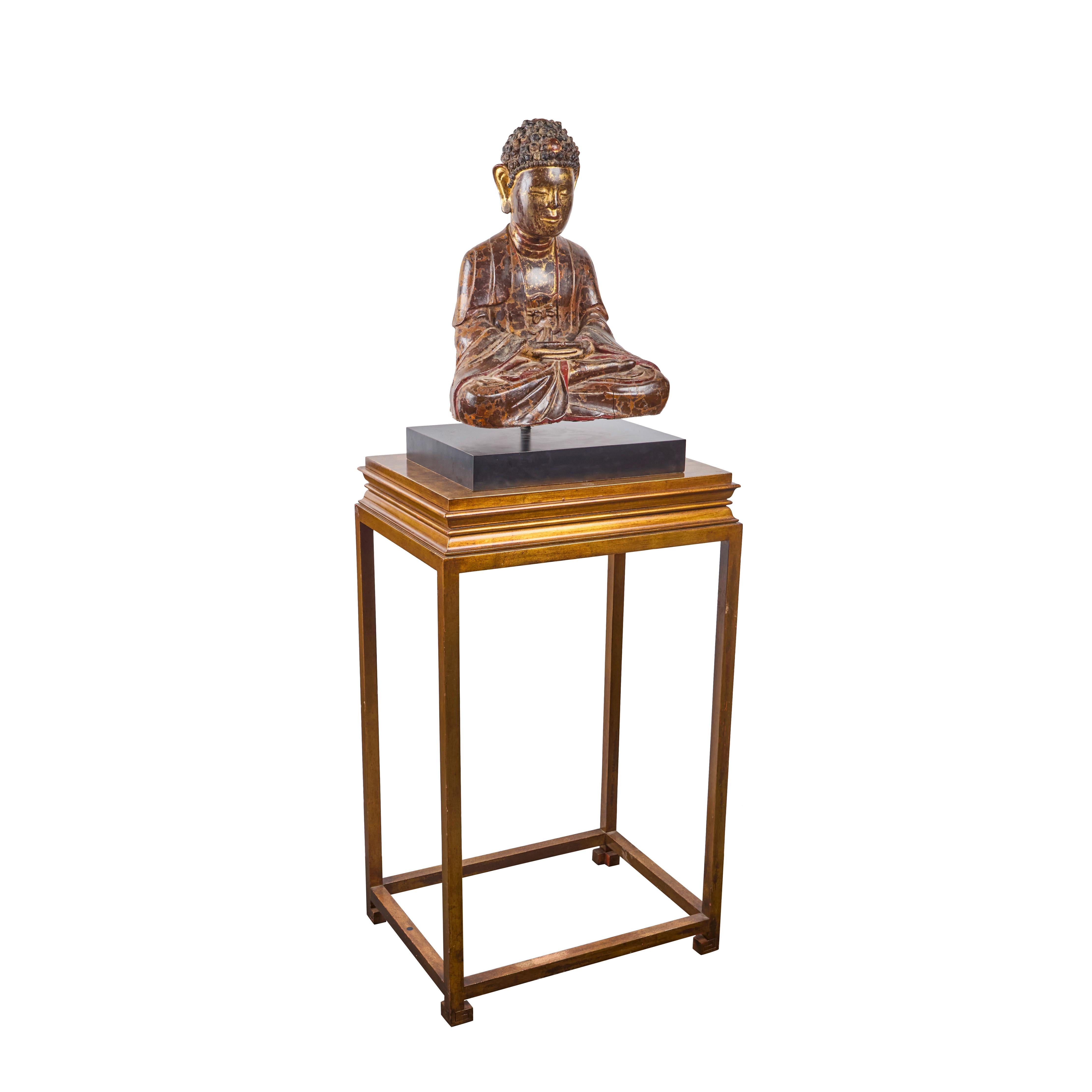 A striking, hand-carved, painted and parcel gilt, seated Buddha mounted on a laminated wooden base, with gilt-wood presentation stand.  
Overall height 64”
Figure and base:  24”H x17“W x 12.75”D
Gilt-wood stand:  40”H x 23.5”W x 17.5”D
