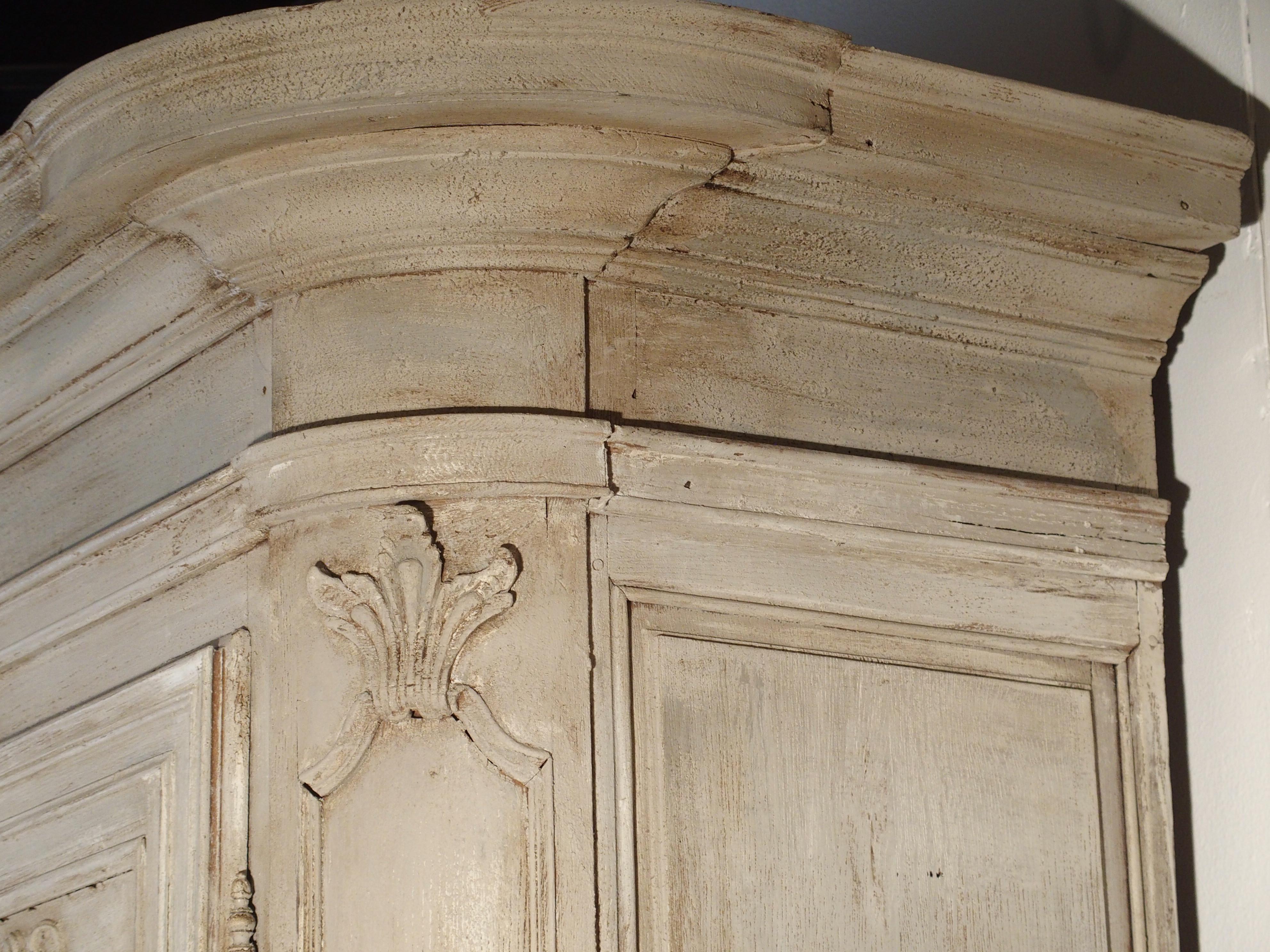 This beautiful painted oak armoire from Ile-de-France (Region of greater Paris) is from the 19th Century. It is unusual in that it has 13 small but deep drawers hidden behind the center panel. The center panel locks into place by a horizontally