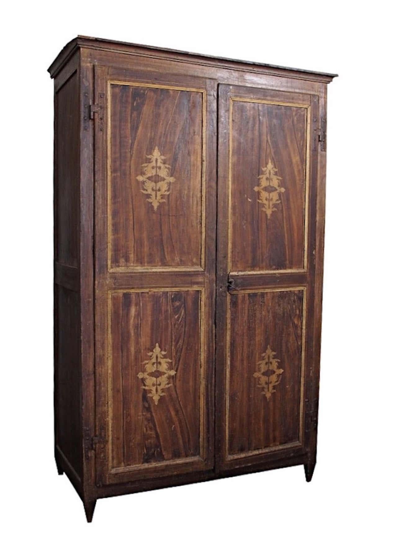 18th century Italian Louis XIV painted armoire two-door faux bois wardrobe with golden neoclassical decorative paint. With working lock and one key. As purchased in Italy with antique decorative interior paper. 

Wear consistent with age. Worn