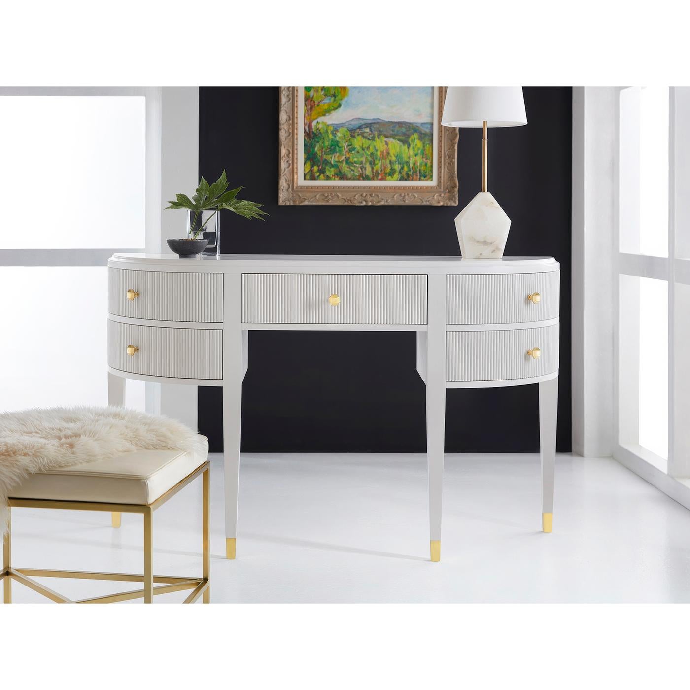Le meuble-lavabo Art Deco célèbre le glamour du design des années 1930 avec sa silhouette démilune et ses détails architecturaux raffinés. La finition blanche nette illustrée dans la teinte White Dove de Benjamin Moore offre un canevas épuré pour