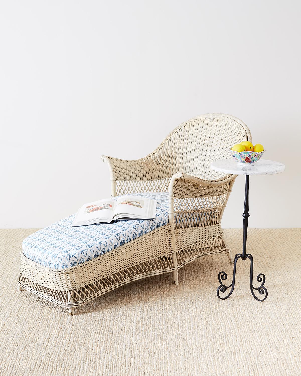Attractive Bar Harbor style willow and wicker chaise lounge or longue featuring a vintage painted finish. The sculptural frame is covered with hand crafted wicker and willow with decorative designs on the back and apron. Supported by six legs that