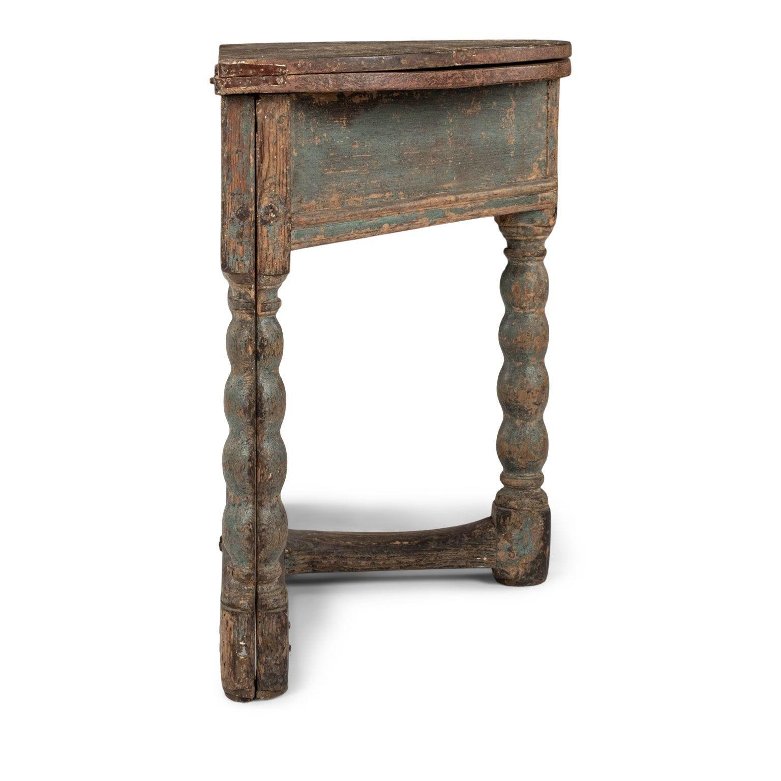 Painted baroque Swedish demilune fold-over table, dating to the late 17th century. Softwood table constructed circa 1670-1699 in Halland, Sweden, with scrubbed demilune top that flips into a full circle. Raised upon a carved bobbin base in original