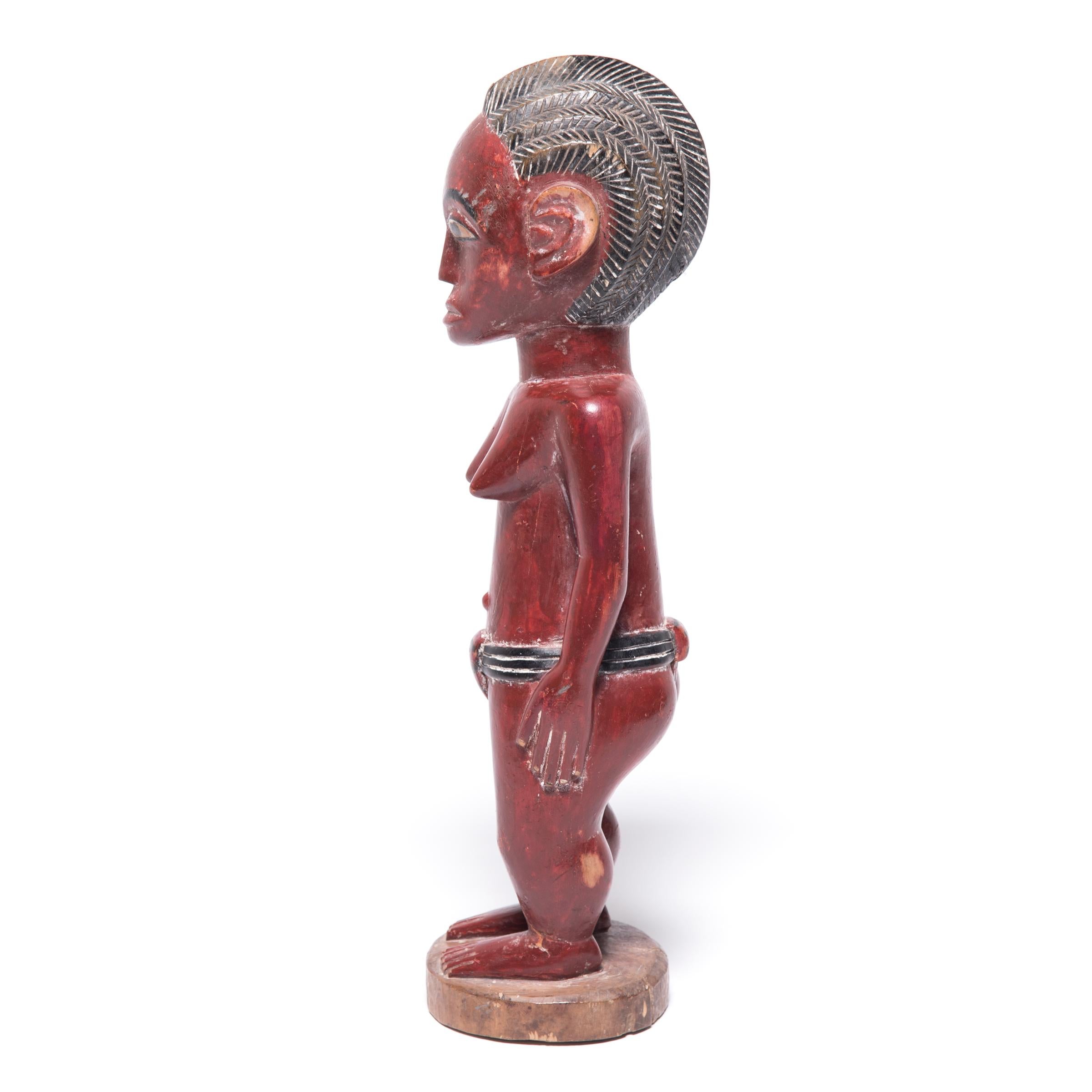 The figurative sculptures of the Baule peoples of Cote d'Ivoire are recognizable by their strong, gently curving forms and serene composure. This figure of a woman was carved to represent the spirit mate of a young Baule man. The Baule believe that