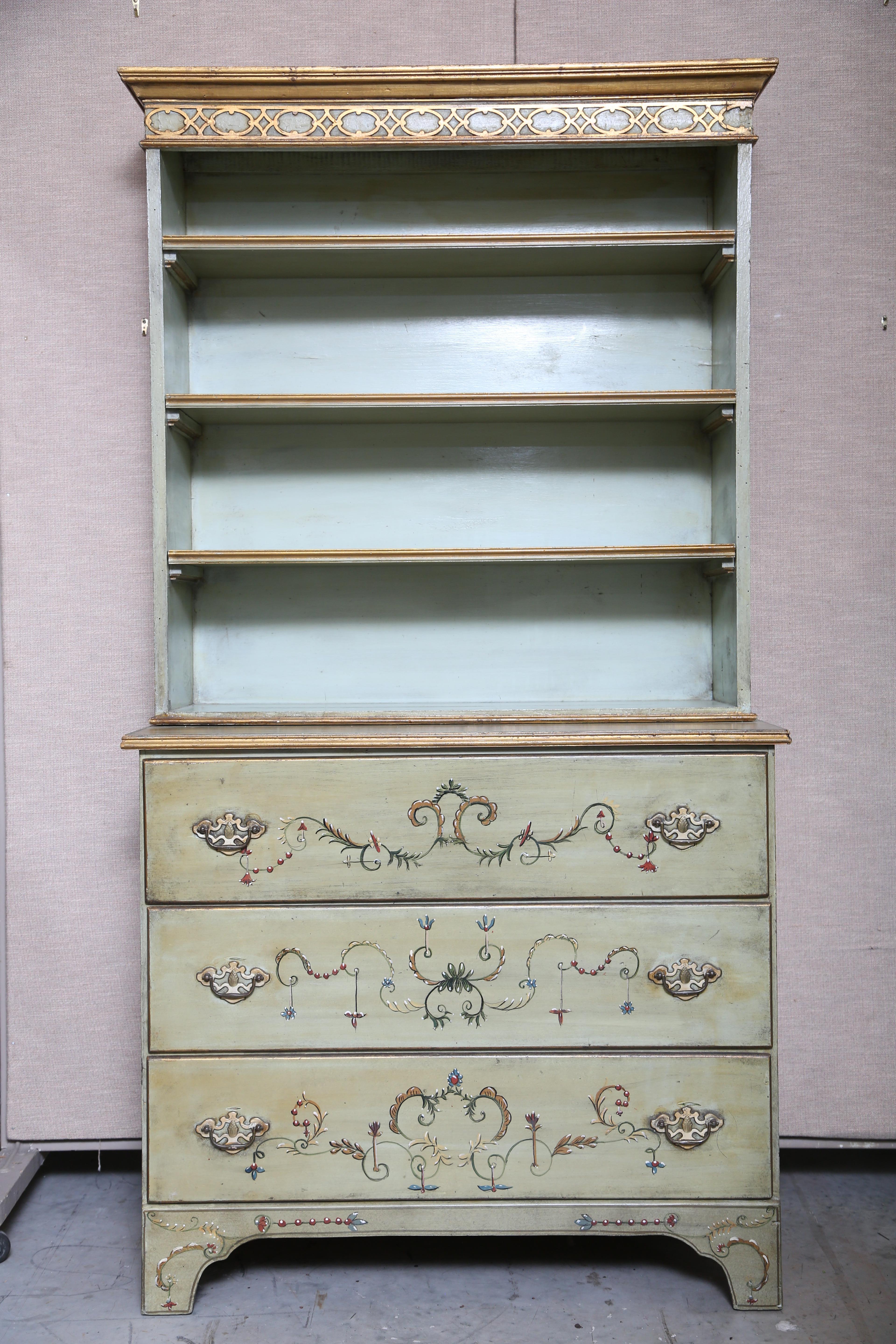 Painted two part  bureau bookcase having three removable shelves. The chest has three spacious drawers below supported by a classic bracket base.  The handles are brass.  The hand painting on the facade is amazing.  The pale celadon ground has