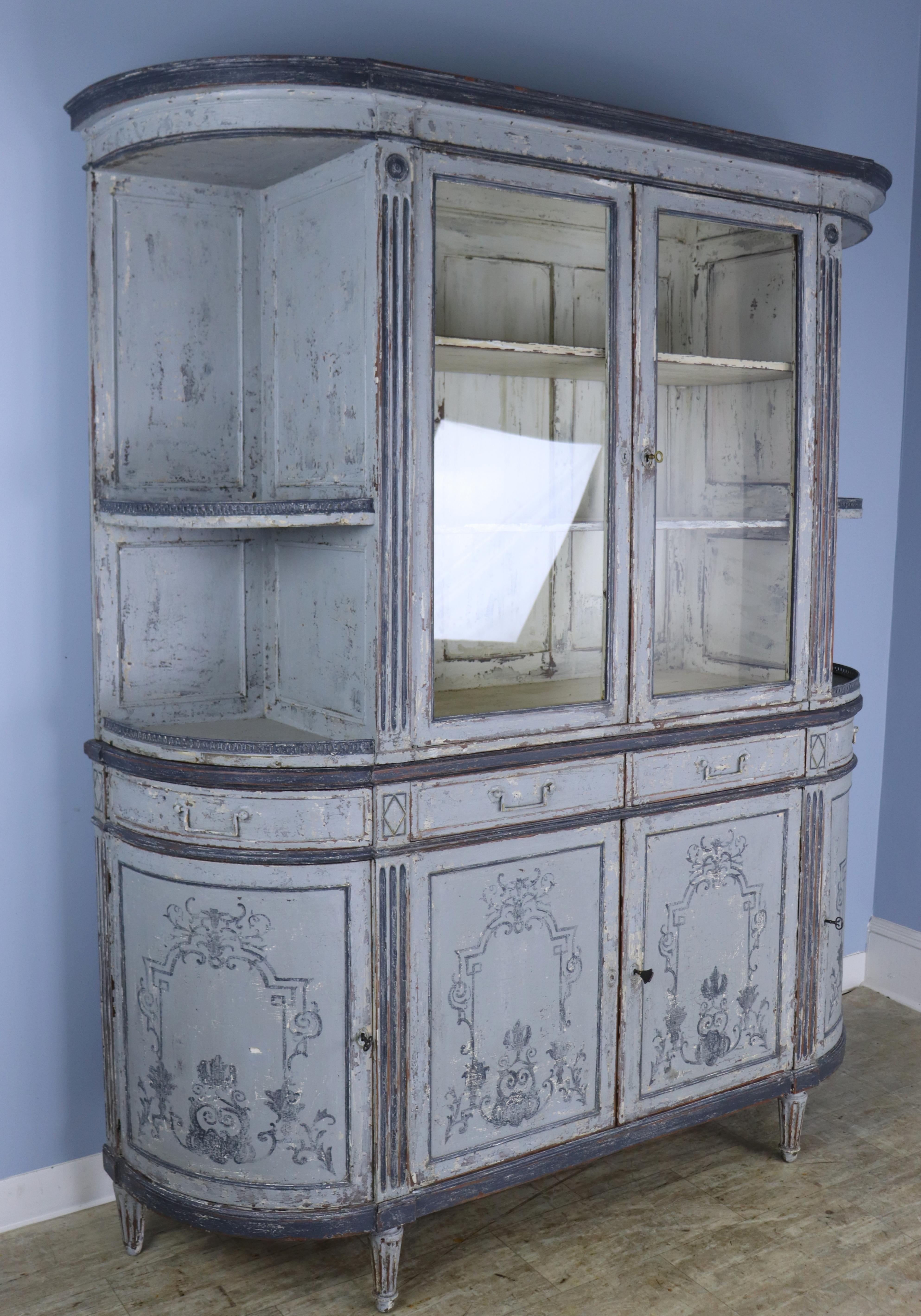 A show stopping Beaux Arts style cabinet with bowed ends.  The gray/lavendar paint has been refreshed and faux distressed but the interior is clean.  Both the drawers and side doors open out 14 inches, so that when they are open the total width of