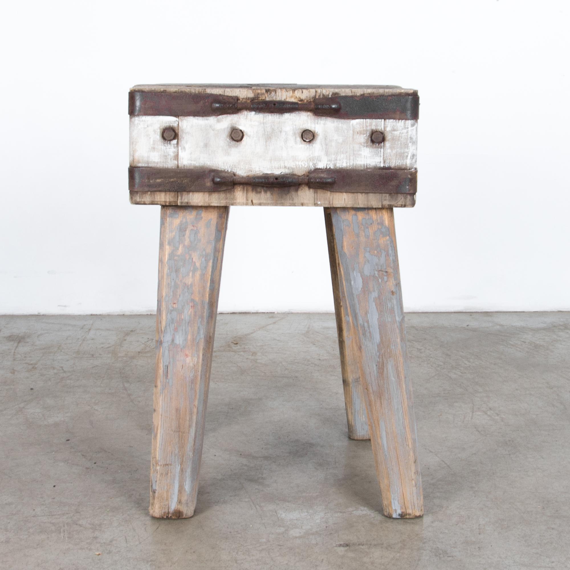 This curious small table comes from France circa 1900, originally used as a butcher block cutting surface. Painted at a later date, a palette of cool grey and white creates a surprising contrast with warm beach wood and oxidized iron braces.