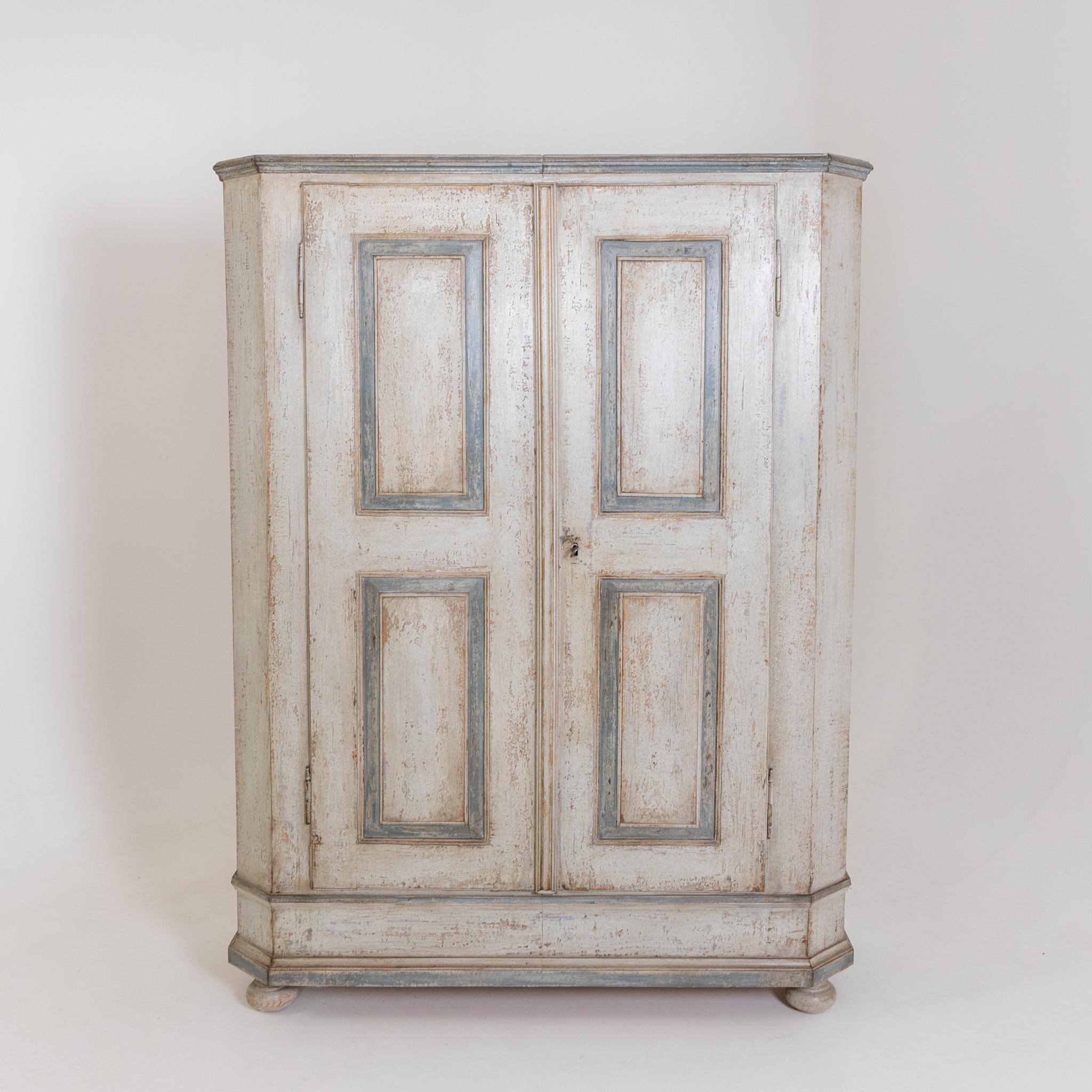 A two-door cabinet with light blue contrasting coffered details on the front and bevelled corners. The creamy white setting is new and has been decoratively rubbed through.