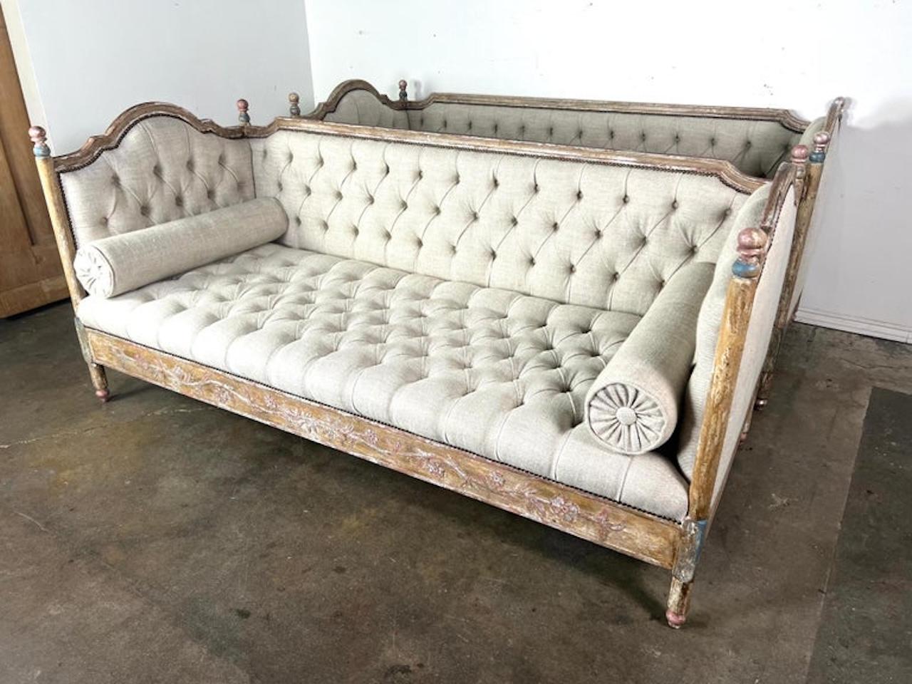 French painted daybed (a pair is available) with a refined and elegant design.  The daybed features a tufted Belgium linen adding texture and a luxurious feel to the piece.

The wooden frame of the daybed is ornate and weathered, with a distressed