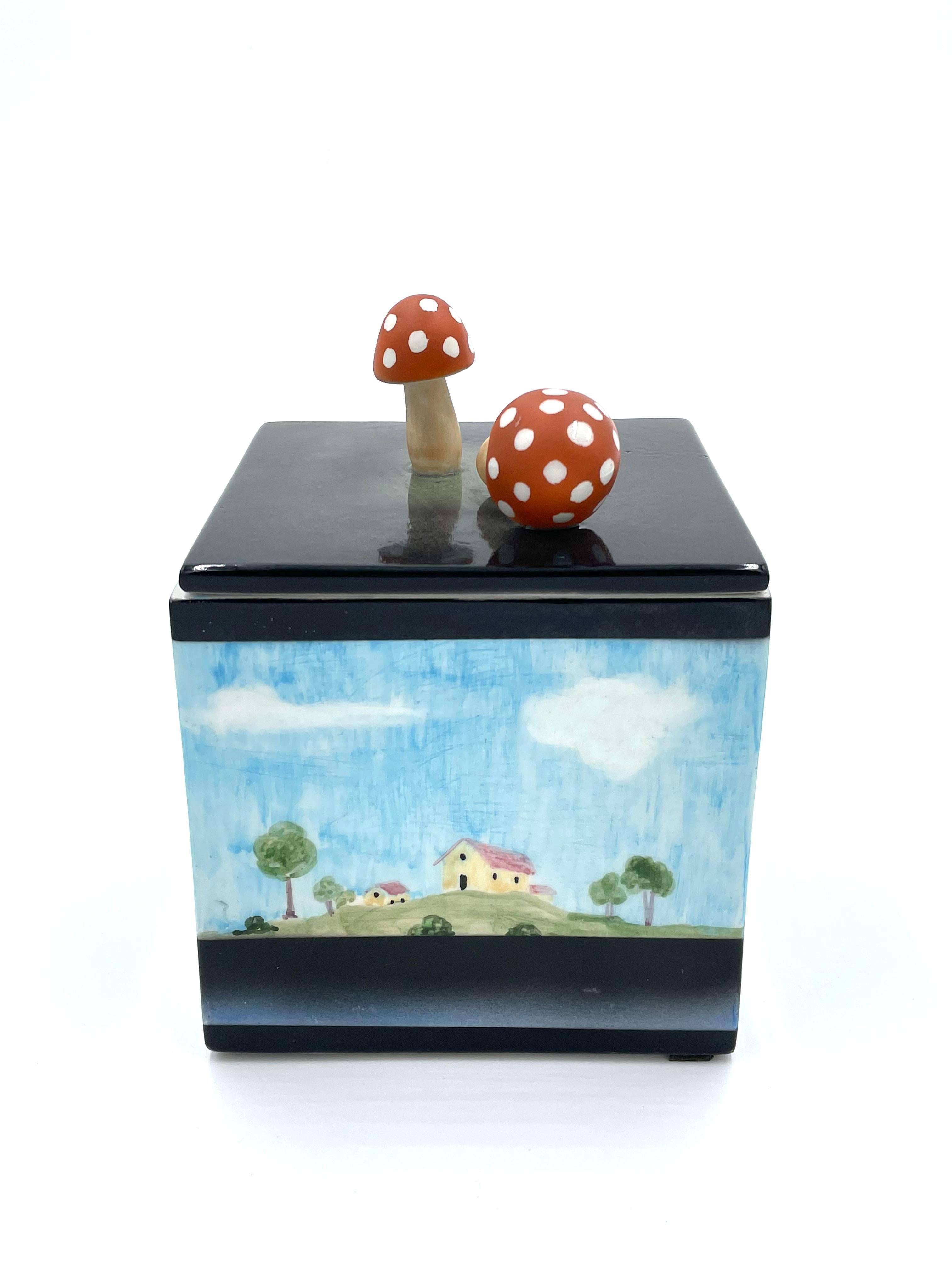 Box made of ceramic by the Lenci Manufactory in Turin, around the late 1950s and early 1960s.

The box in question is is cubic in shape and features a lid with a figurative knob, as two mushrooms are depicted. The side faces of the box are painted