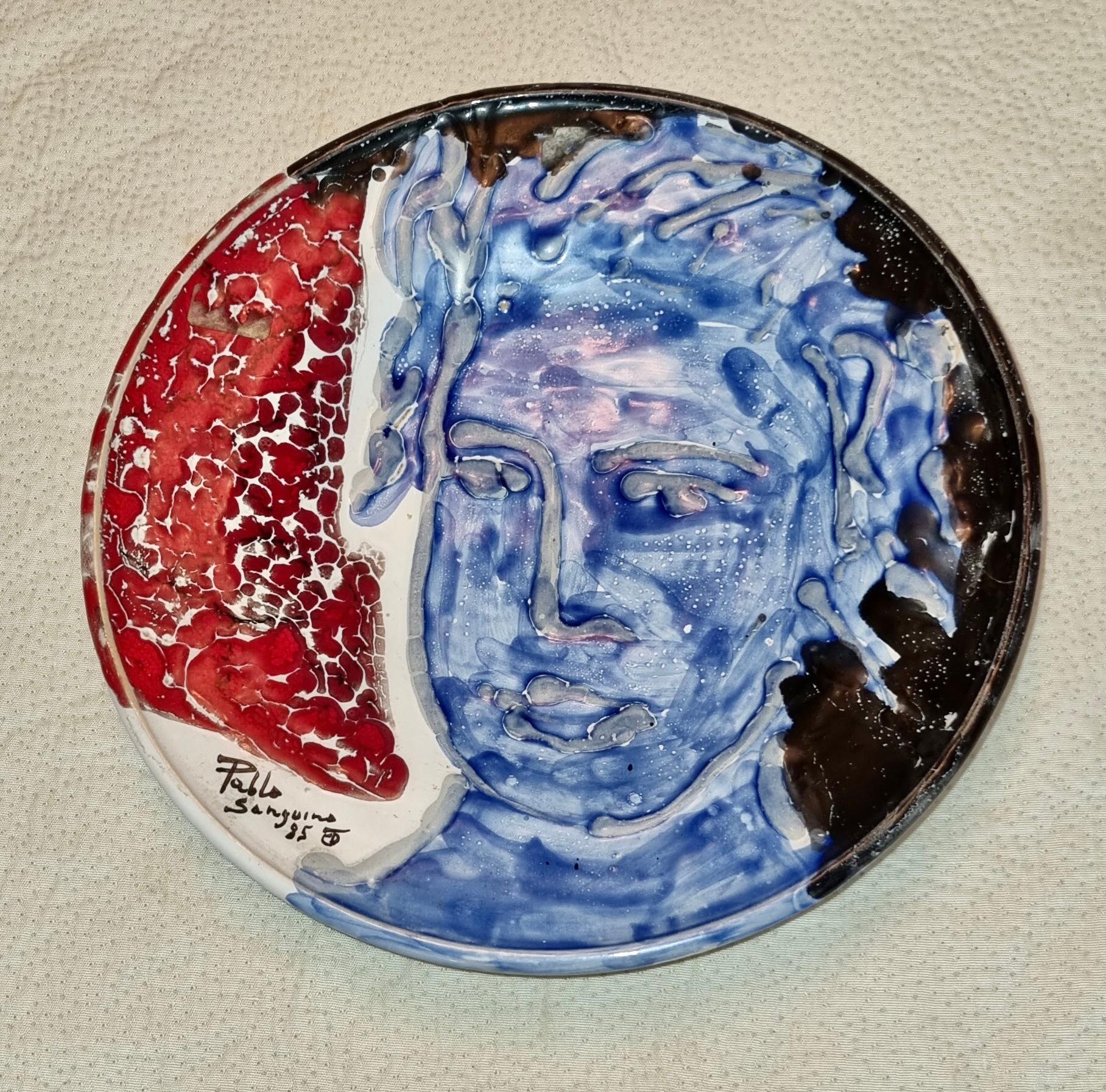 Ceramic plate with painting of a mans face in surreal mediterranean style
by Toledian artis Pablo Sanguino
Pablo Sanguino, born in 1949 in Puente del Arzobispo, belongs to a tradition of potters who ended up settling in Toledo in 1955, in a