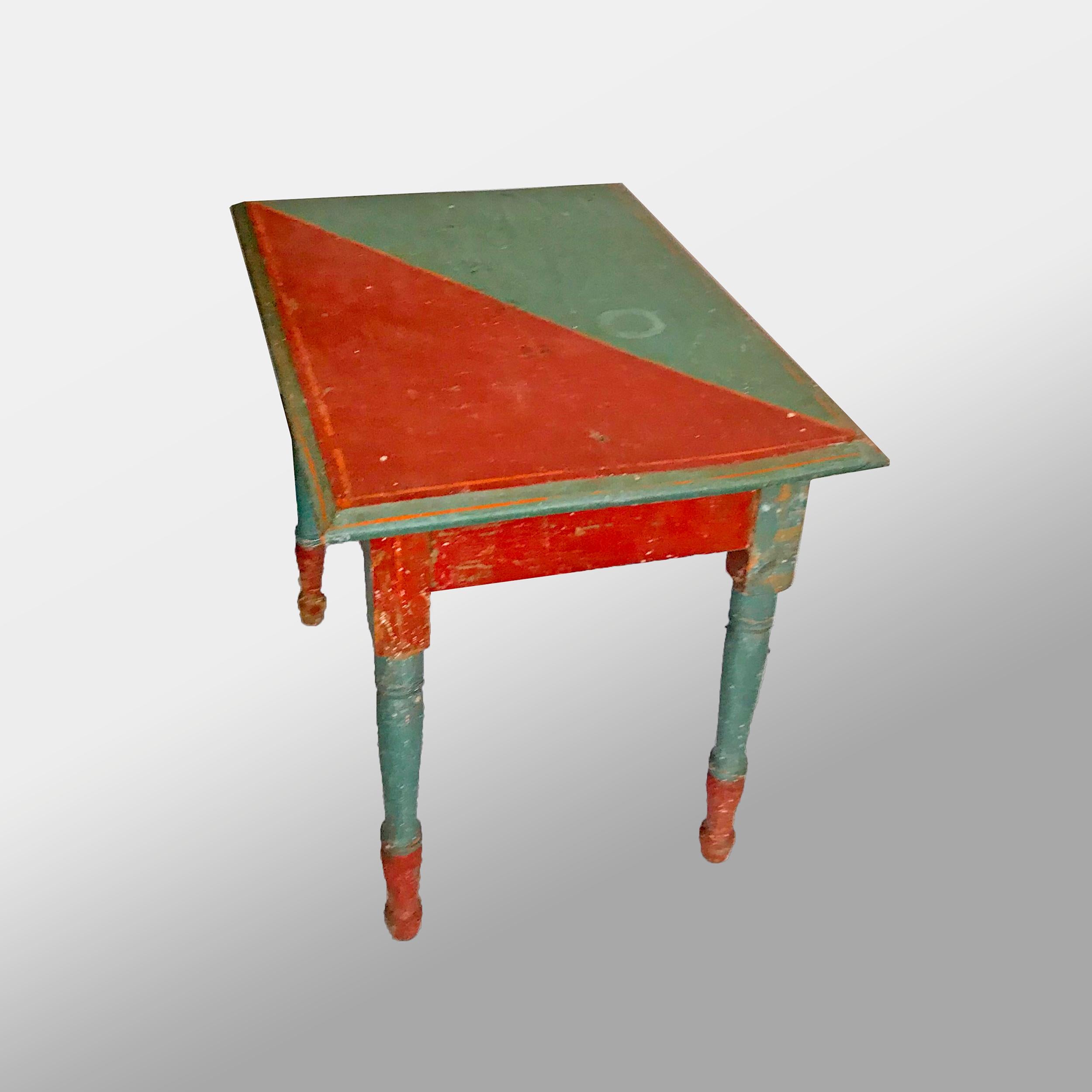 Made of pine and decorated with a red and blue pattern throughout with orange stringing border on top and a single knob-less drawer on spool turned legs.
American, circa 1900-1920
Measures: 20 ¼” x 24” x 17 ¼”.
 