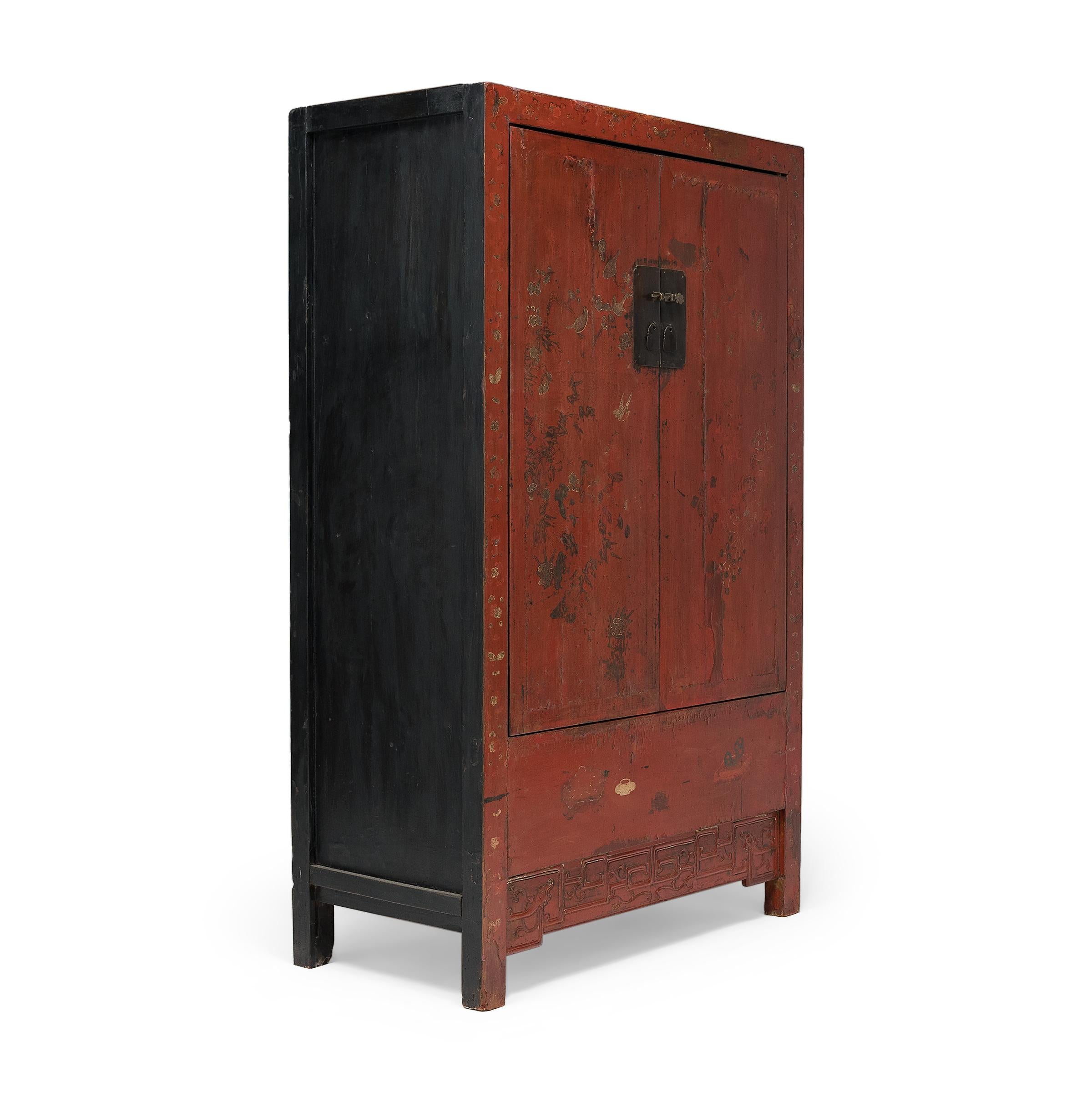 Crafted in the mid-19th century, this tall cabinet has a clean-lined form, designed with straight sides, square corners and minimal carvings. The cabinet front is cloaked in a bright, cinnabar-red lacquer finish, contrasted by black lacquer sides