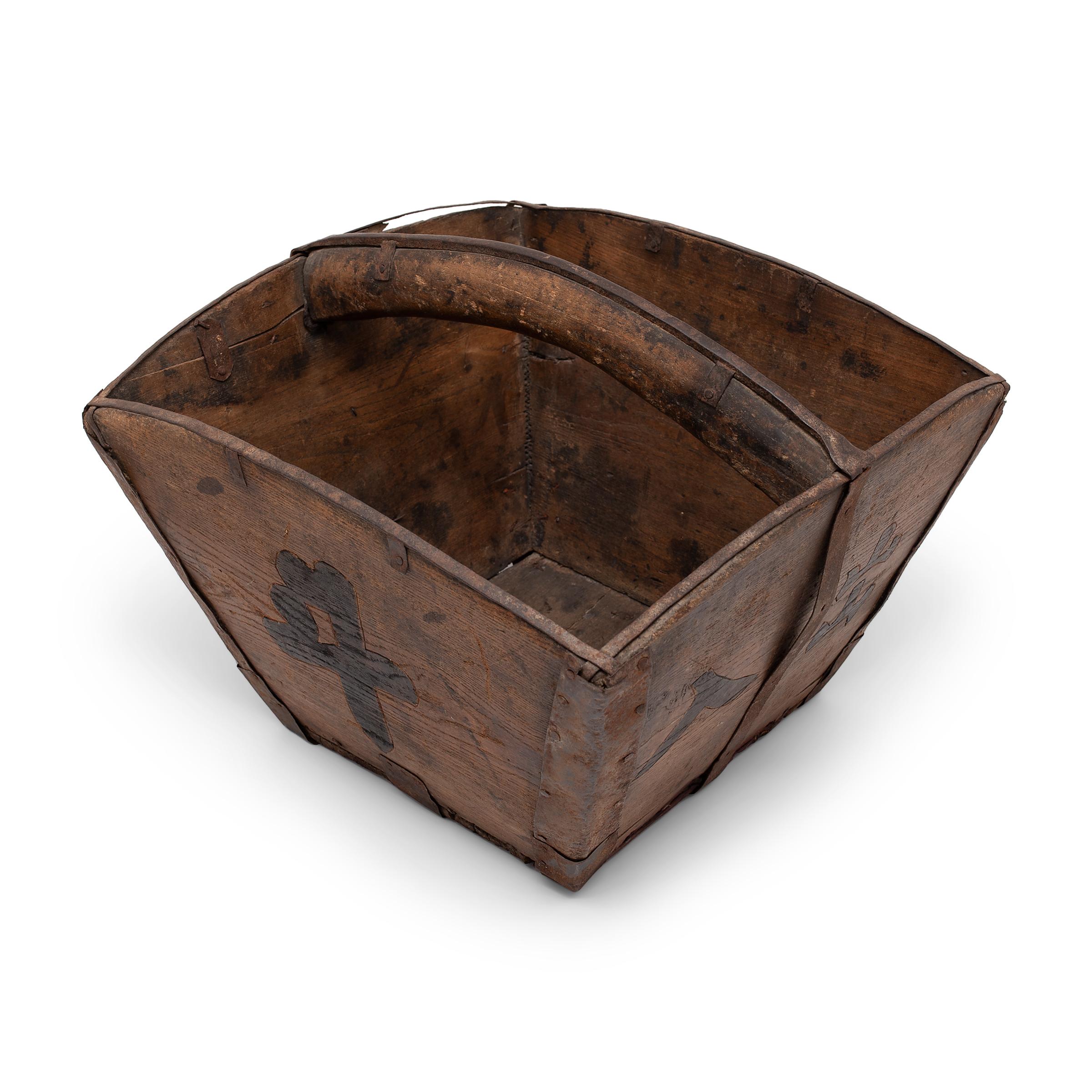 This rustic container was made over a hundred years ago to measure and hold a dou of rice, an ancient Chinese measurement. The wooden vessel has a squared form, hand-crafted with tapered sides and an arched top strengthened with iron trim. The flat