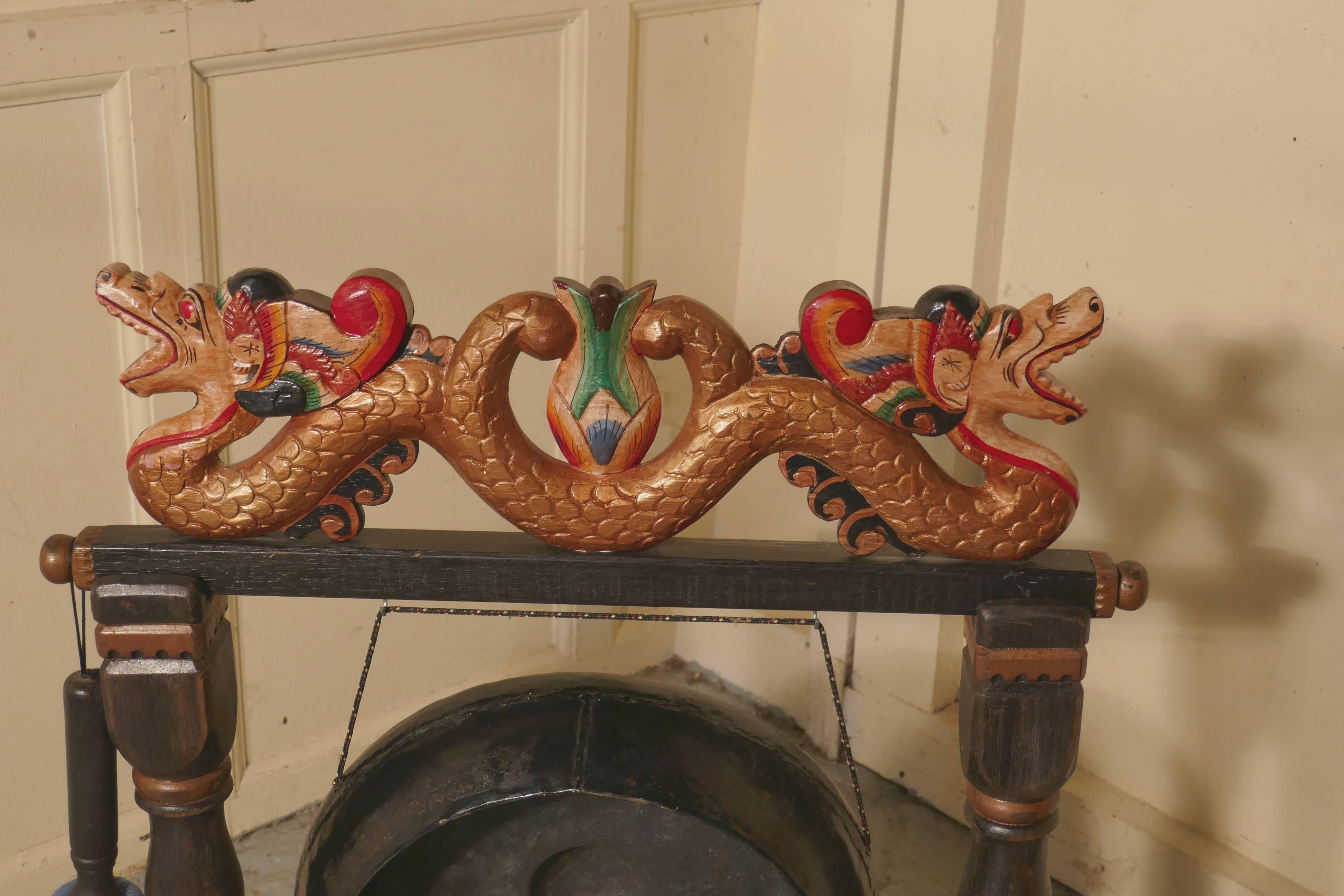 Gong de table chinois peint. 

Il s'agit d'une pièce très lumineuse et colorée:: le support est en bois sculpté:: gaufré et peint en relief avec des dragons dos à dos avec leurs queues entrelacées pour la chance et la bonne fortune. 

Le gong est