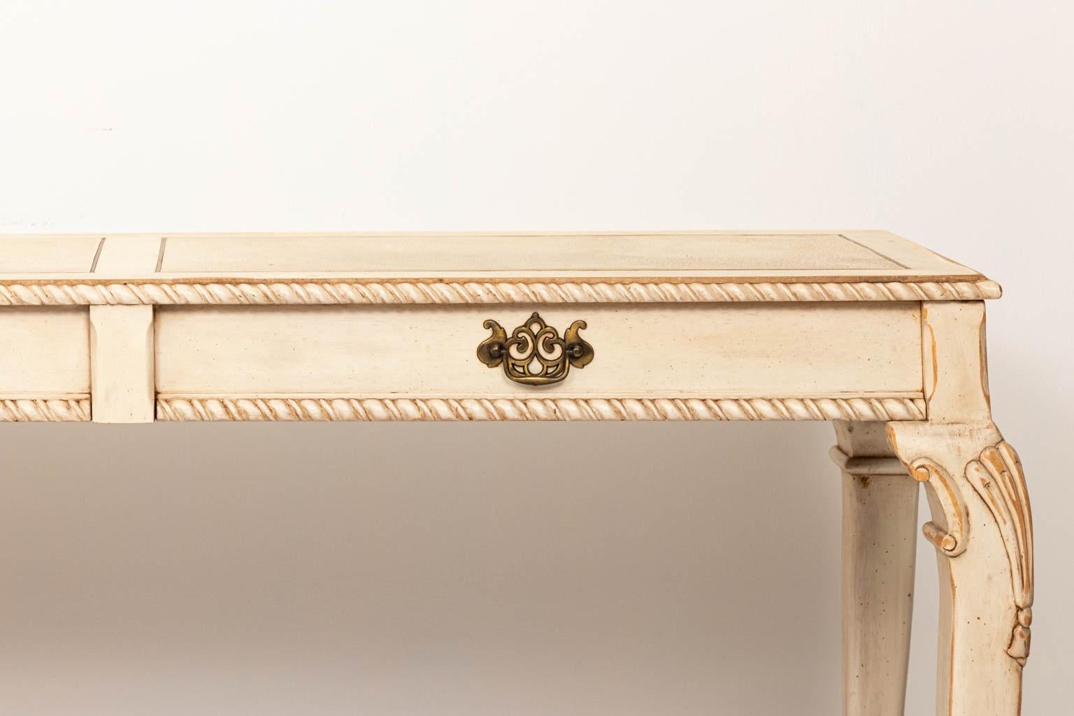 Chippendale ball and claw console table on casters. Inlaid brass on top. Painted off-white distressed finish
Good condition, wear to painted finish from age and use.