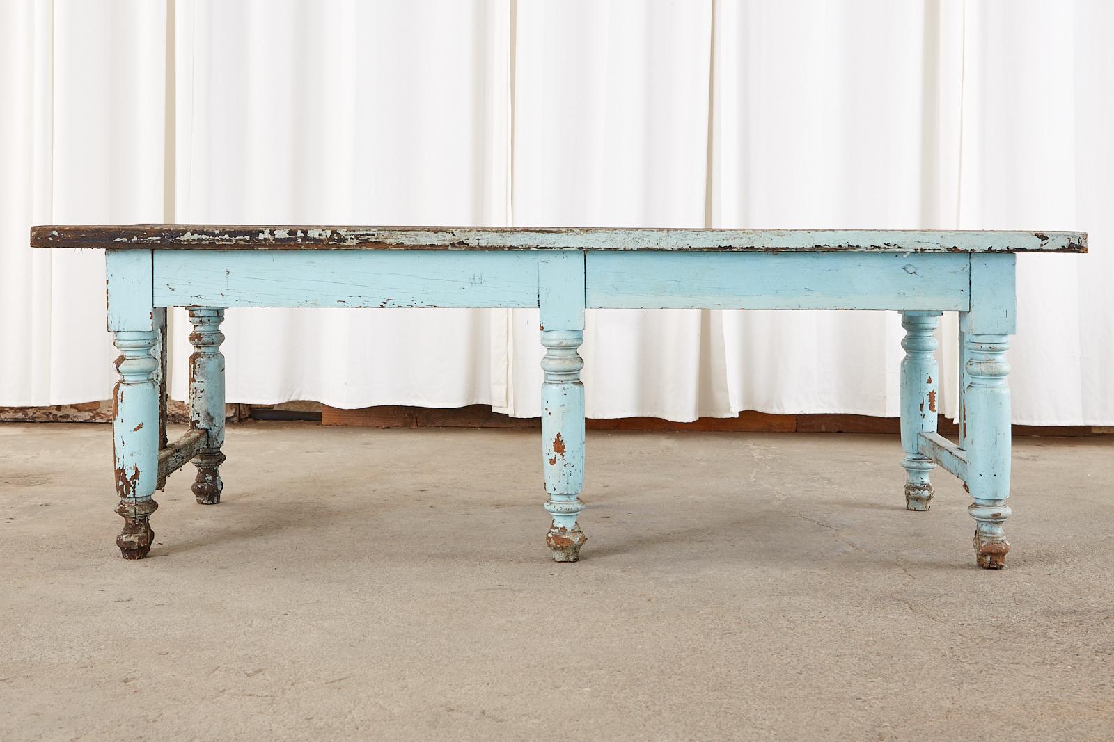 Rustic early 20th century country English farmhouse potting table or work table crafted from hardwood probably oak. The table is very heavy, strong and solid featuring a nearly 2 inch thick plank top and frieze. Painted in a charming robin's egg