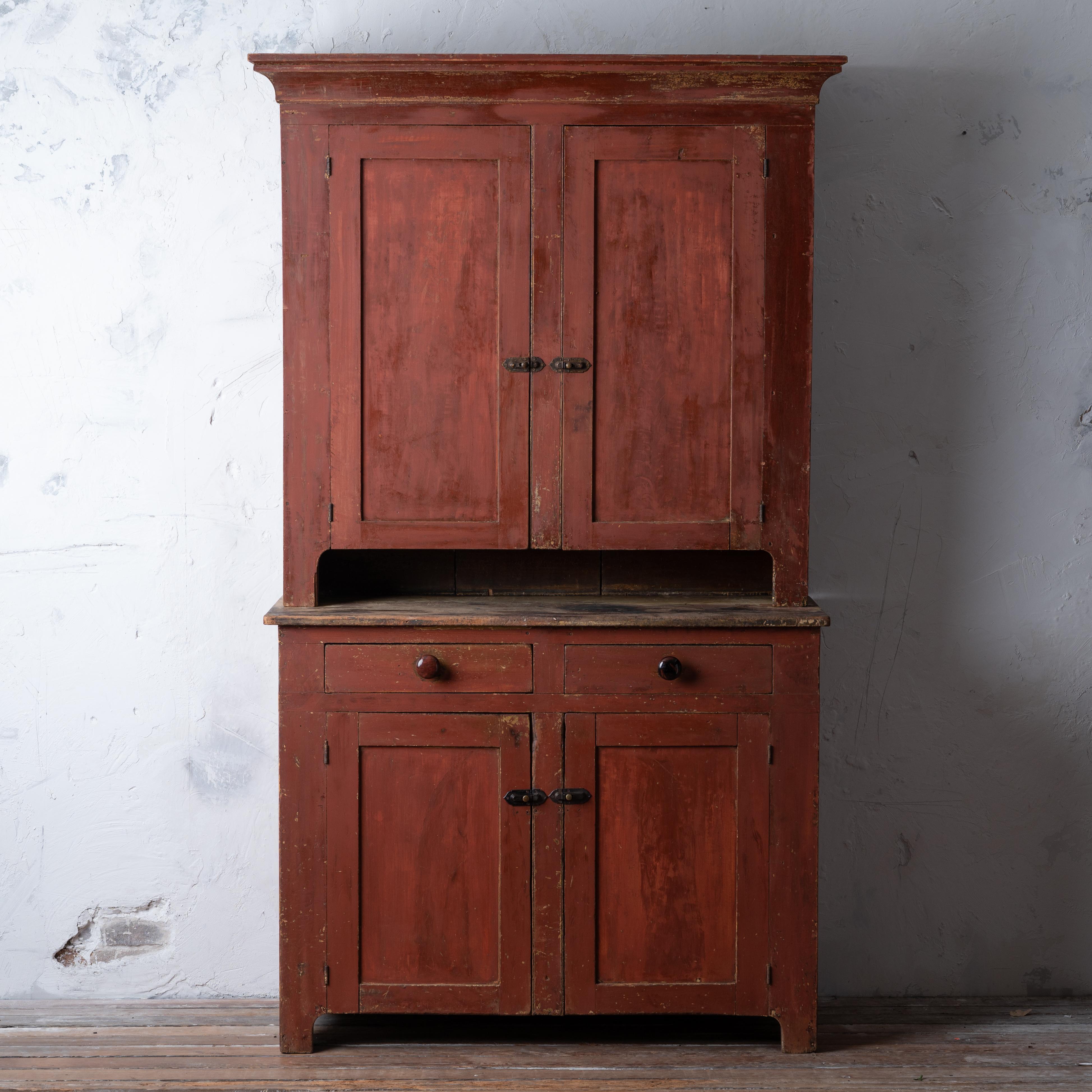 An American primitive painted cupboard, circa 1840s.

47 ¼ inches wide by 21 inches deep by 83 ¾ inches tall;

height of lower cabinet 37 inches;

upper shelves 10 inches deep, lower shelves 18 inches deep

