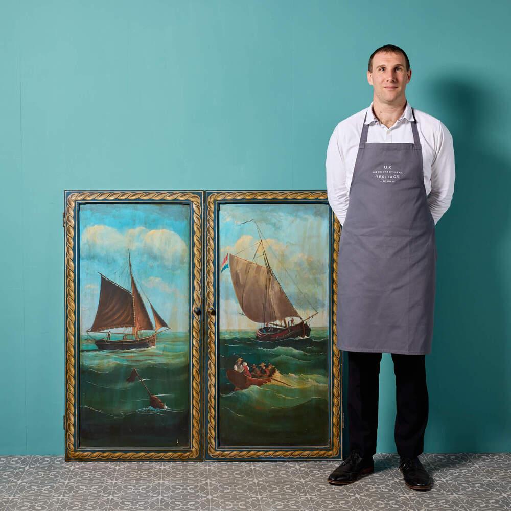 A set of unusual reclaimed hand painted cupboard doors, depicting a maritime scene. Finely painted, these 20th century cupboard doors have stood the test of time, with the subject beautifully captured. Two masted ships and a rowing boat are seen