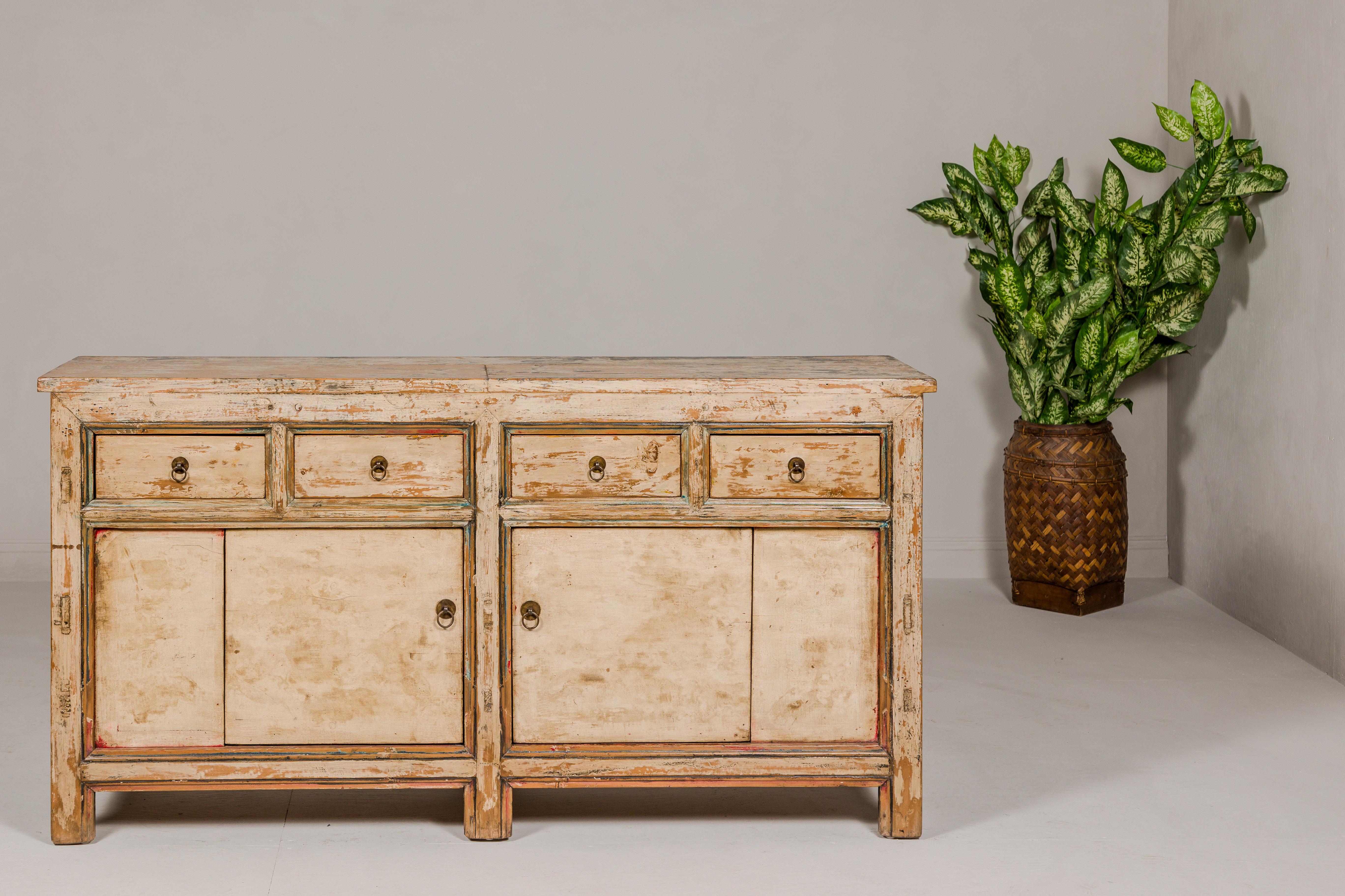 A painted elm rustic sideboard from the mid 20th century, with distressed finish, two doors and four drawers. This mid-20th-century painted elm rustic sideboard is a splendid blend of timeworn charm and elegant restoration. It boasts a distressed