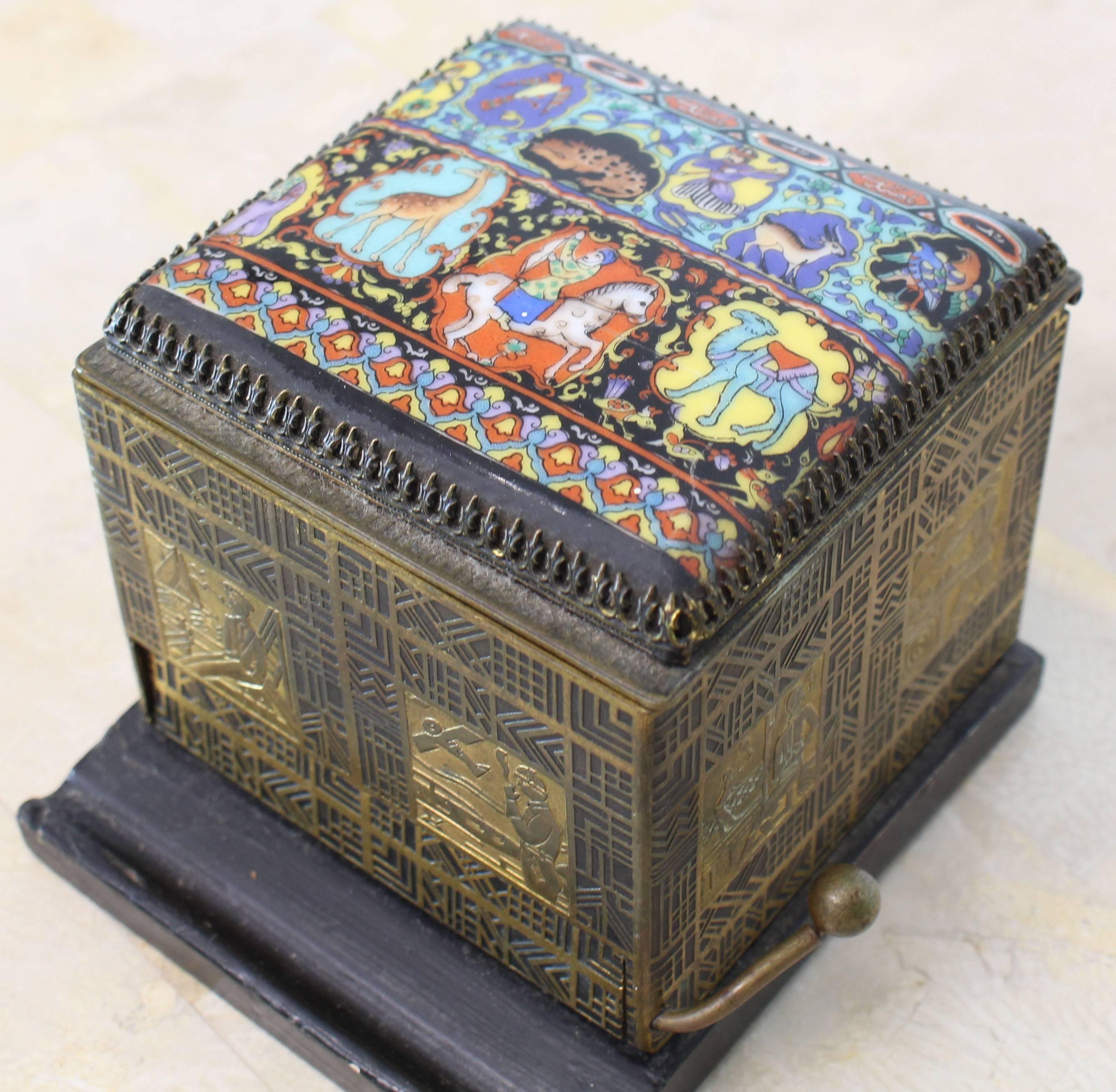 Muy bonita caja dispensadora de cigarrillos de porcelana pintada sobre metal grabado Art Decó con motivos laterales.