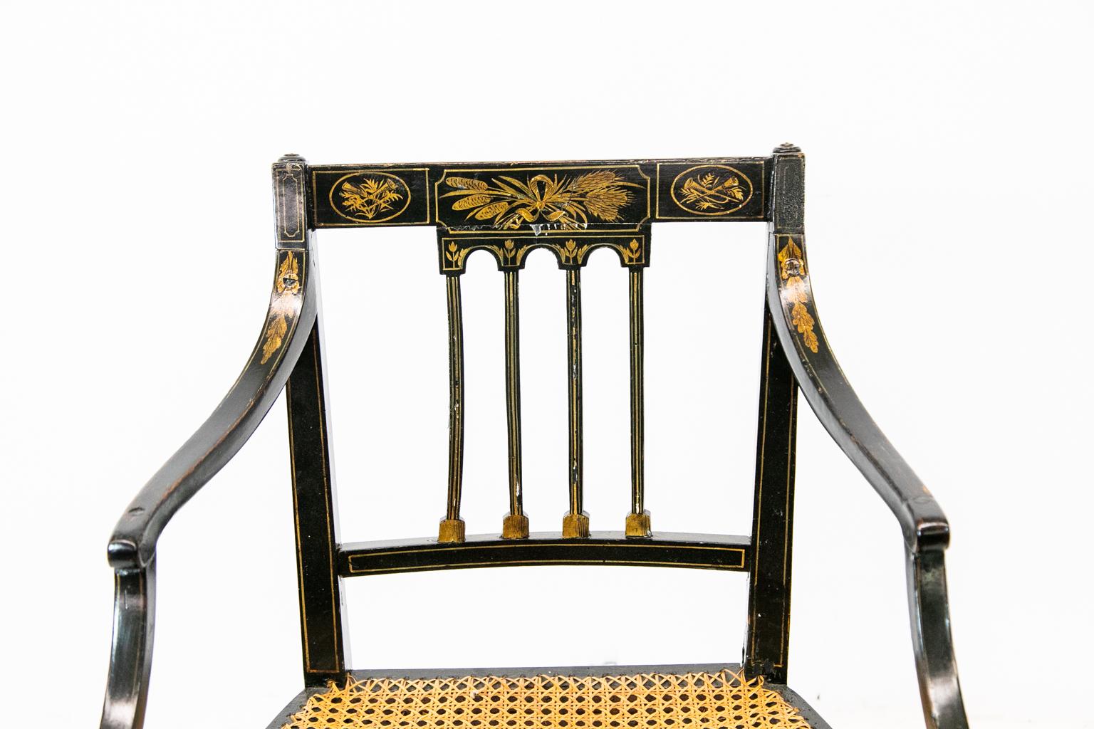 Painted English Hepplewhite Arm Chair is painted with wheat trumpets, acanthus leaves, ribbons, and flowers. The cane seat is in good condition.