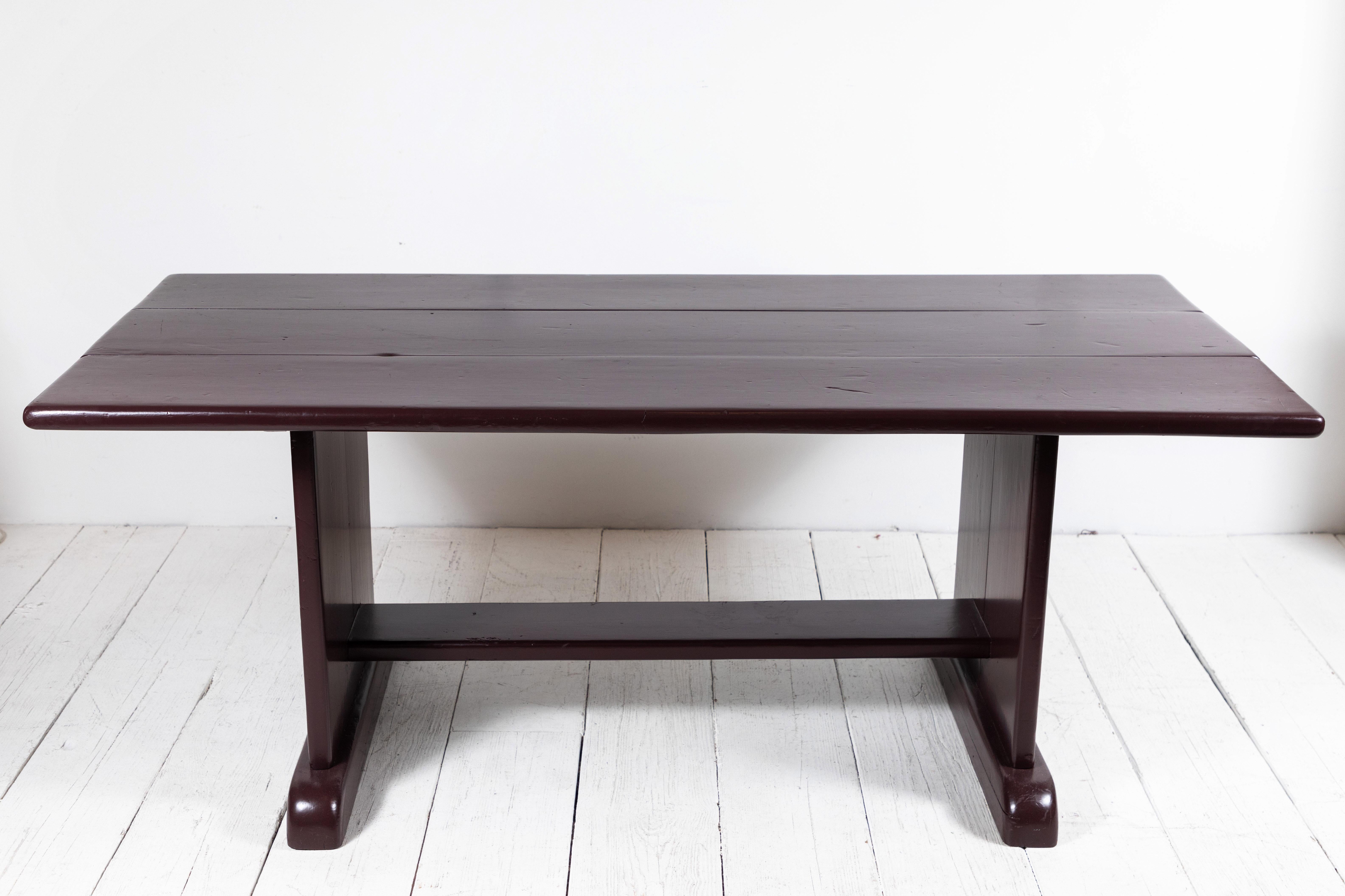 Painted deep aubergine farm table with sold paneled trestle base.