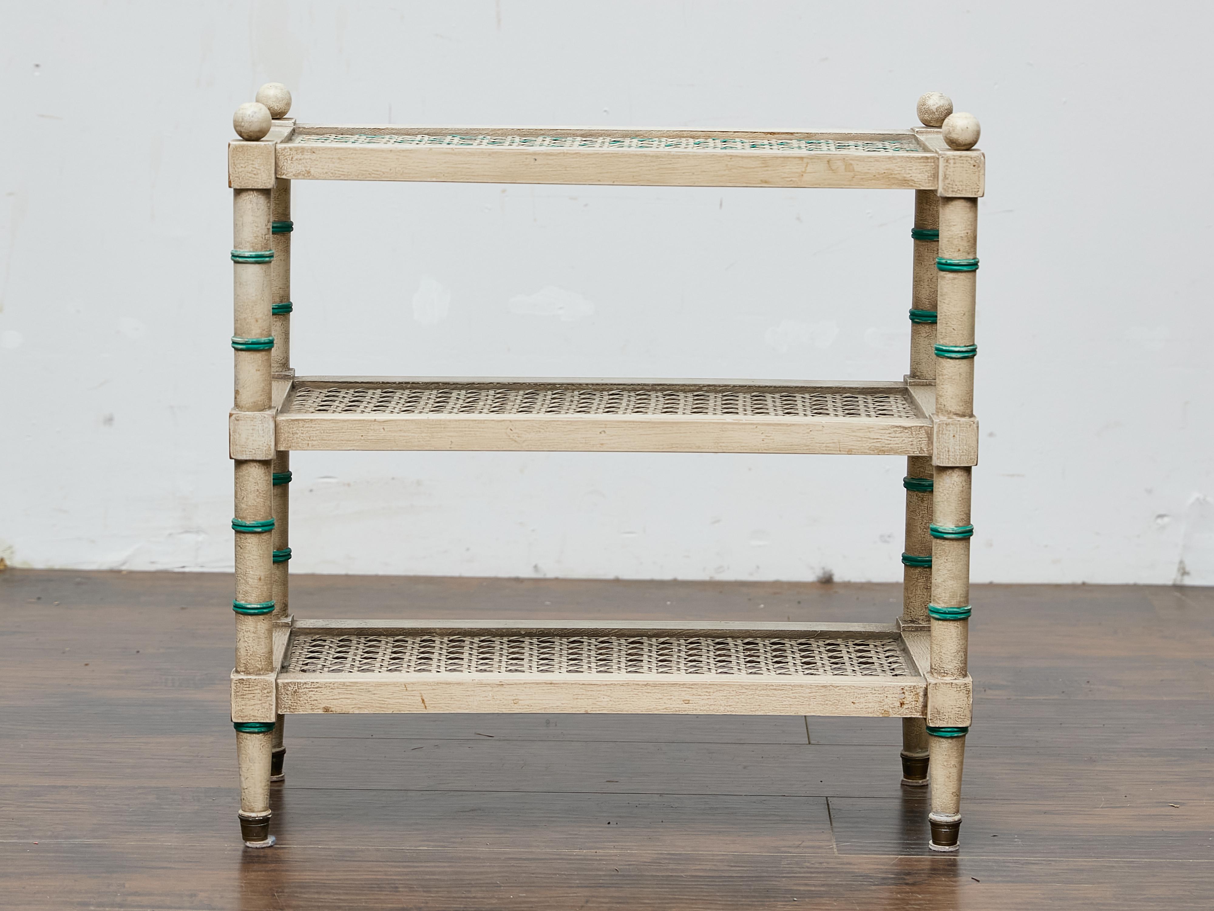 A charming example of Midcentury faux bamboo design, this painted three-tier étagère combines playful form with practical function. The structure is crafted from solid wood, hand-painted in a creamy, slightly distressed finish that mimics the warmth