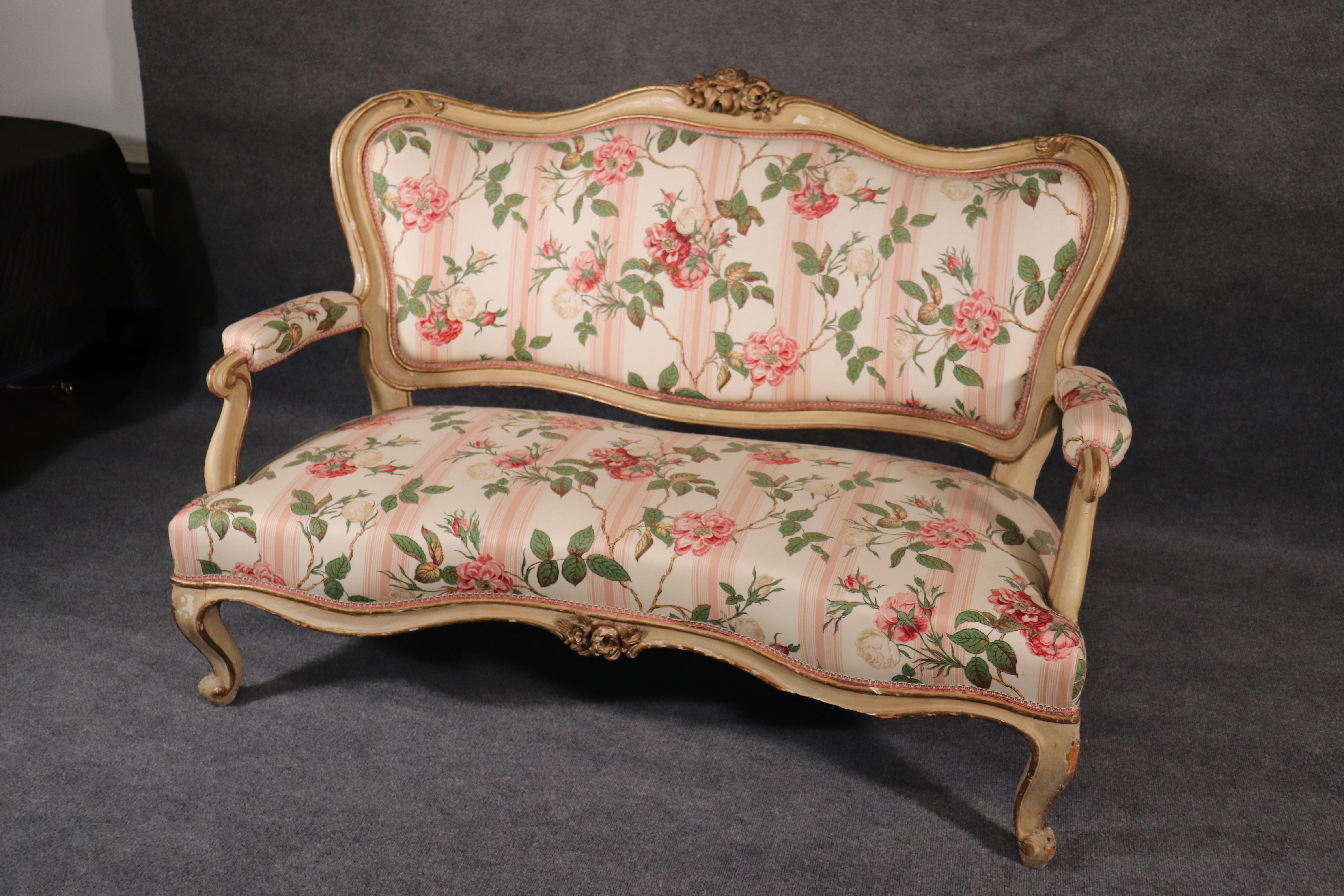This is a beautiful French-made rococo paint decorated settee with floral upholstery in good condition. The settee dates to the 1890s and is very chic and can match many different design schemes. The settee measures 59.25 wide x 29 deep x 40.5 tall.