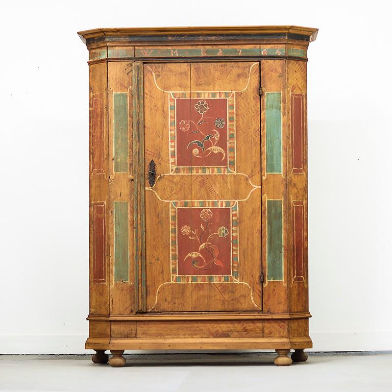 Cabinet de mariage très décoratif datant de 1764. L'armoire a conservé sa peinture d'origine et a un aspect très rustique. Cet exemple est décoré de panneaux et de peintures florales ; la peinture est assez usée et certaines moulures ont été