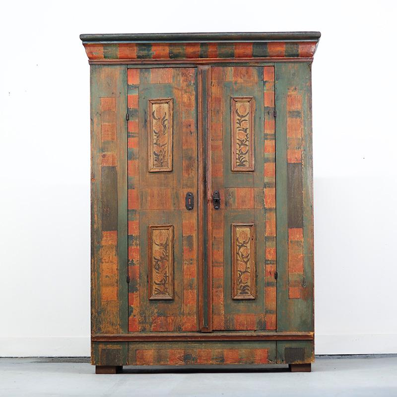 Une extraordinaire armoire de mariage ancienne en pin datant de 1790. Ce meuble est de conception simple mais magnifiquement peint, principalement en vert et en rouge, avec des décorations florales sur les panneaux. Compte tenu de son âge, cette