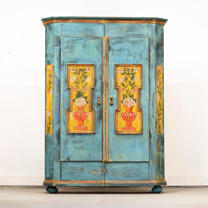 Uno straordinario armadio da sposa antico in pino risalente al 1825 circa. Questo mobile ha un design semplice ma è splendidamente dipinto in un fresco blu con decorazioni floreali nei pannelli. La vernice azzurra si è consumata magnificamente nel