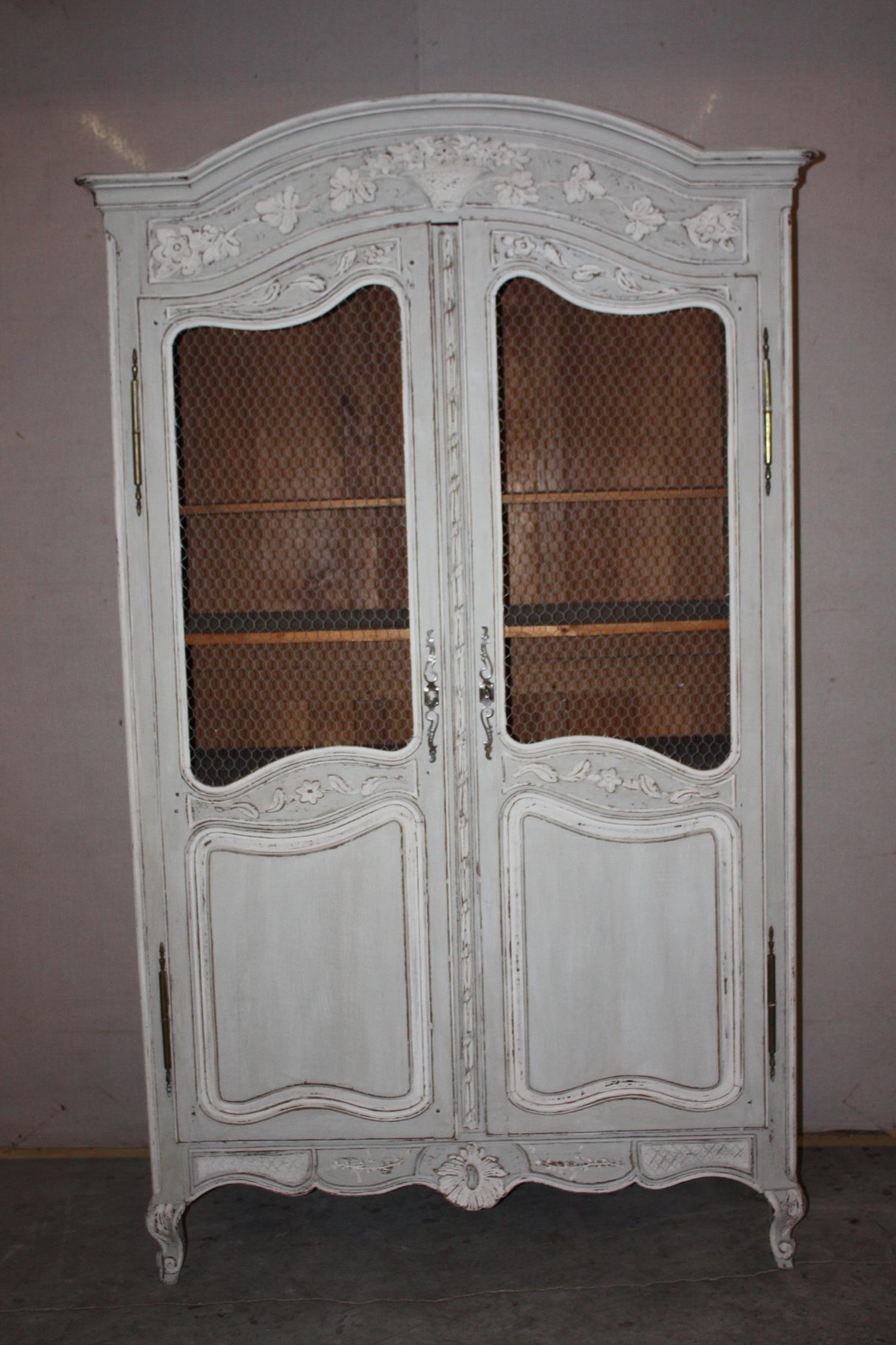 This is a very nice French painted armoire that dates to the late 1800s-early 1900s. It has a chicken wire upper panel on the doors. The shelves are adjustable.
