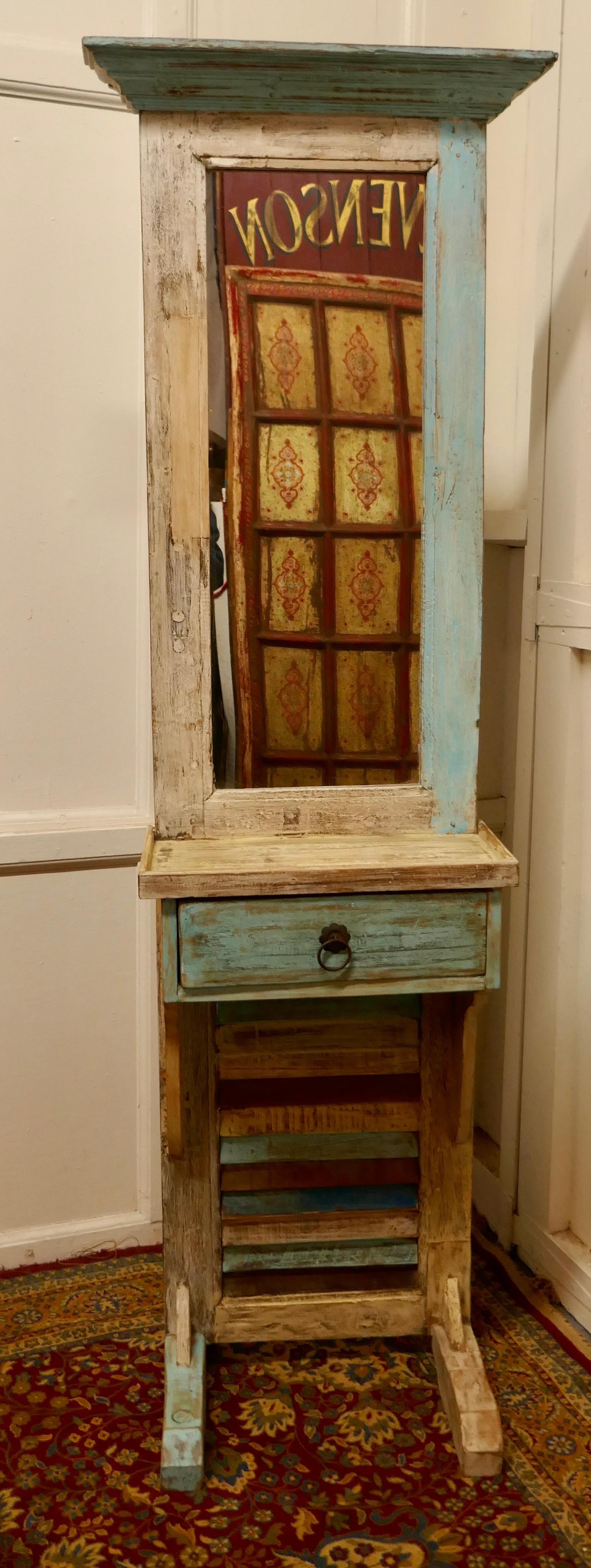Painted French bathroom or cloakroom mirror stand

This is an unusual piece, it is made using a tall narrow window shutter
The stand has a long mirror in the centre and beneath this a small counter with a drawers below
This piece is shabby