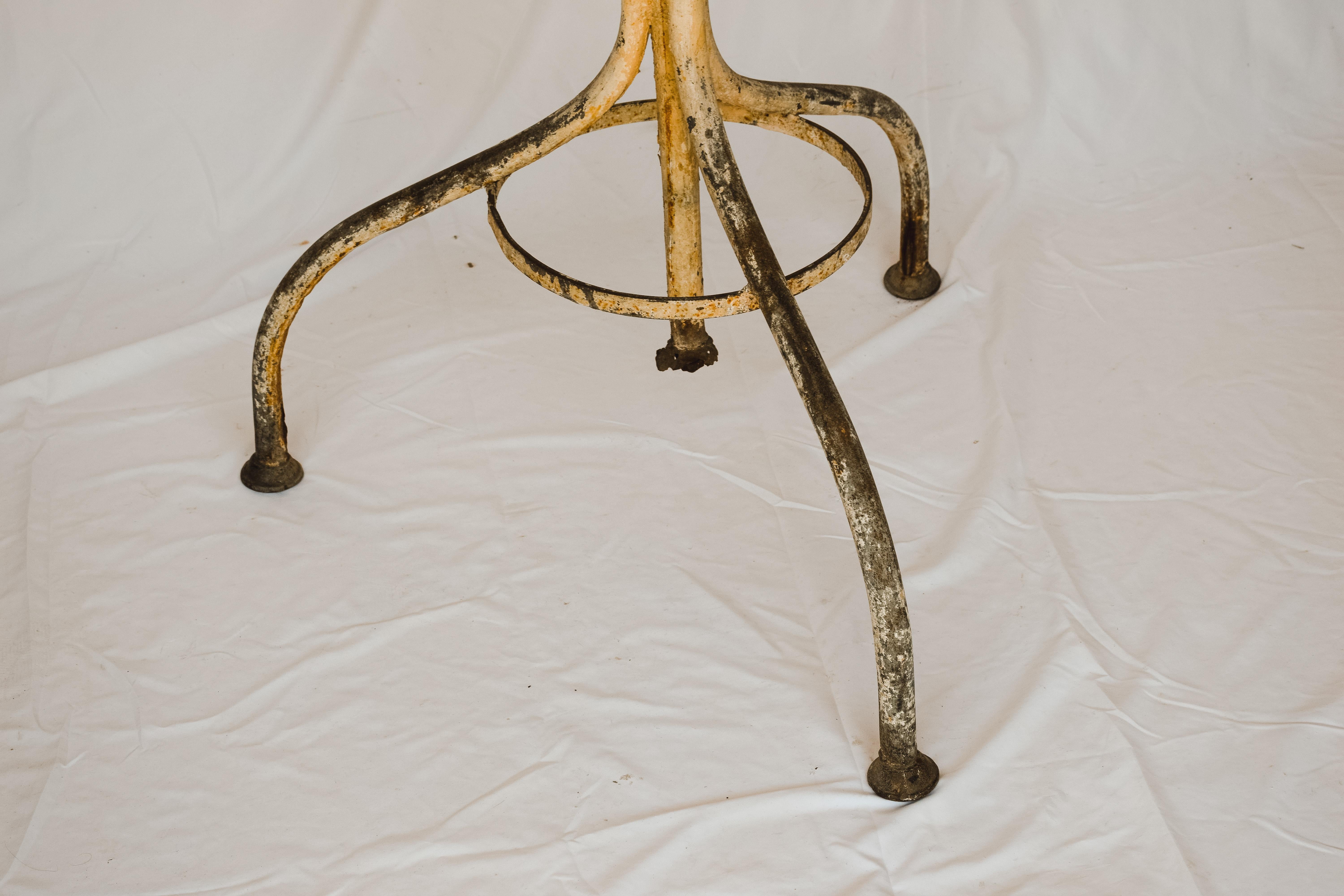 Classic central European hall tree in wrought and cast iron. The usual anthropomorphic double hooks are typical for this design. A circular tube holds umbrellas. In old worn and chipped paint. Placed in an entry, bedroom or bathroom this piece is a