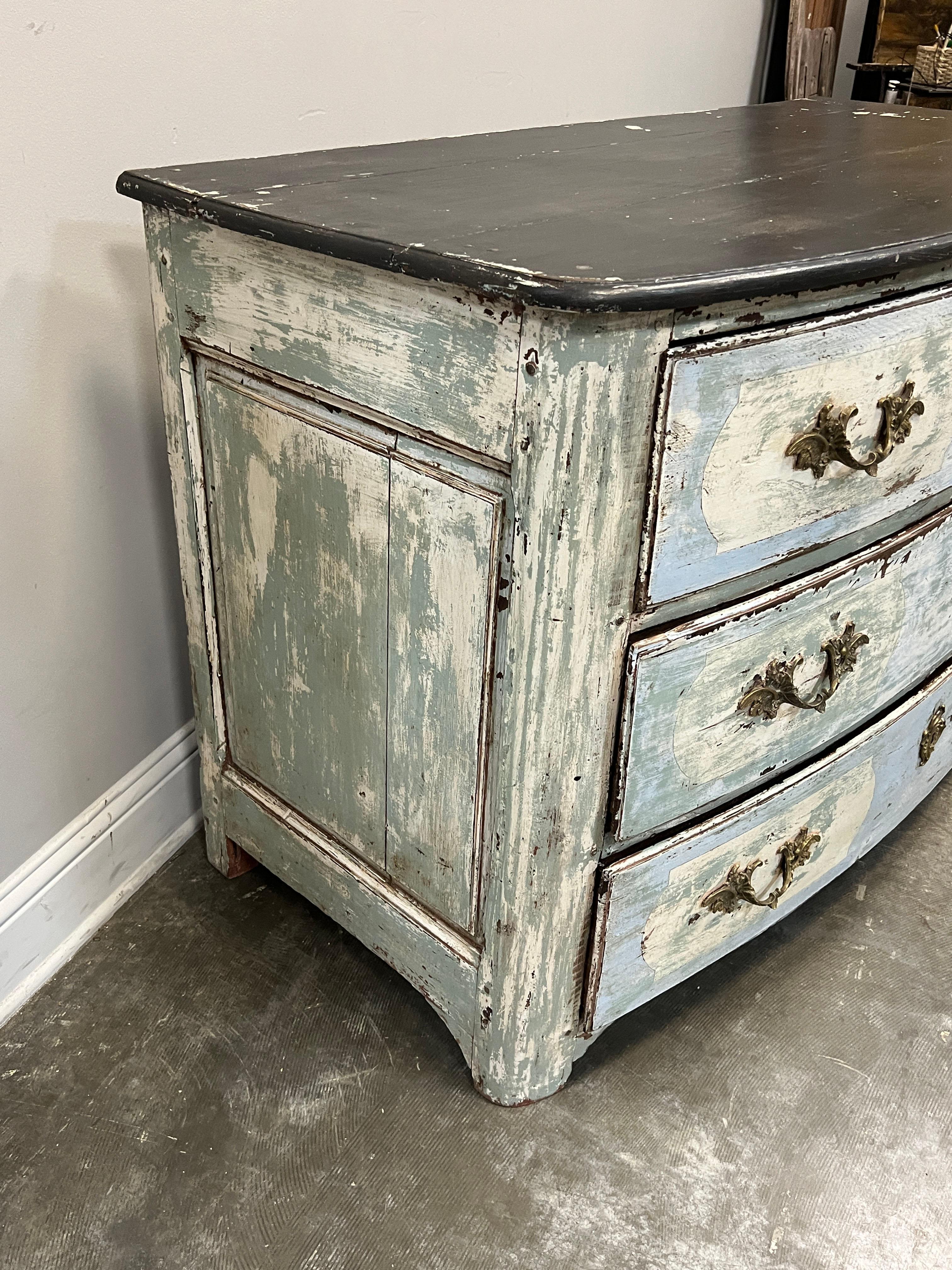 This is a beautiful French Provincial Louis XVI style painted bow front commode. The piece is hand crafted in the mid 18th century, France. 

Decorative painting appearing turquoise blue with cream or white accent was applied and executed to appear