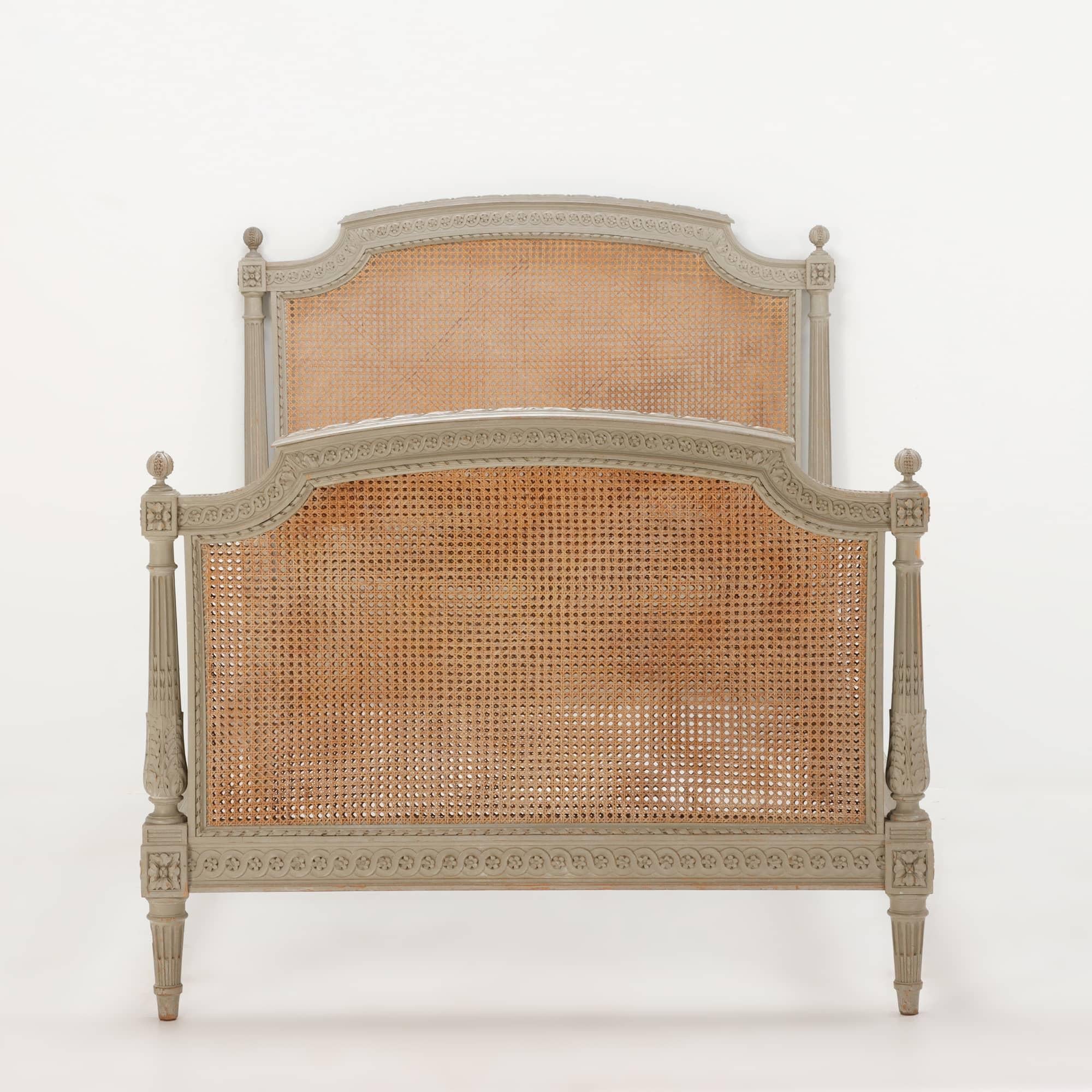 Painted French Louis XVI style carved wood and cane youth or twin size bed C 1930. This bed has a cane headboard and double caned footboard. The photos speak for themselves as it is a beauty. The size is slightly larger than the typical twin bed so