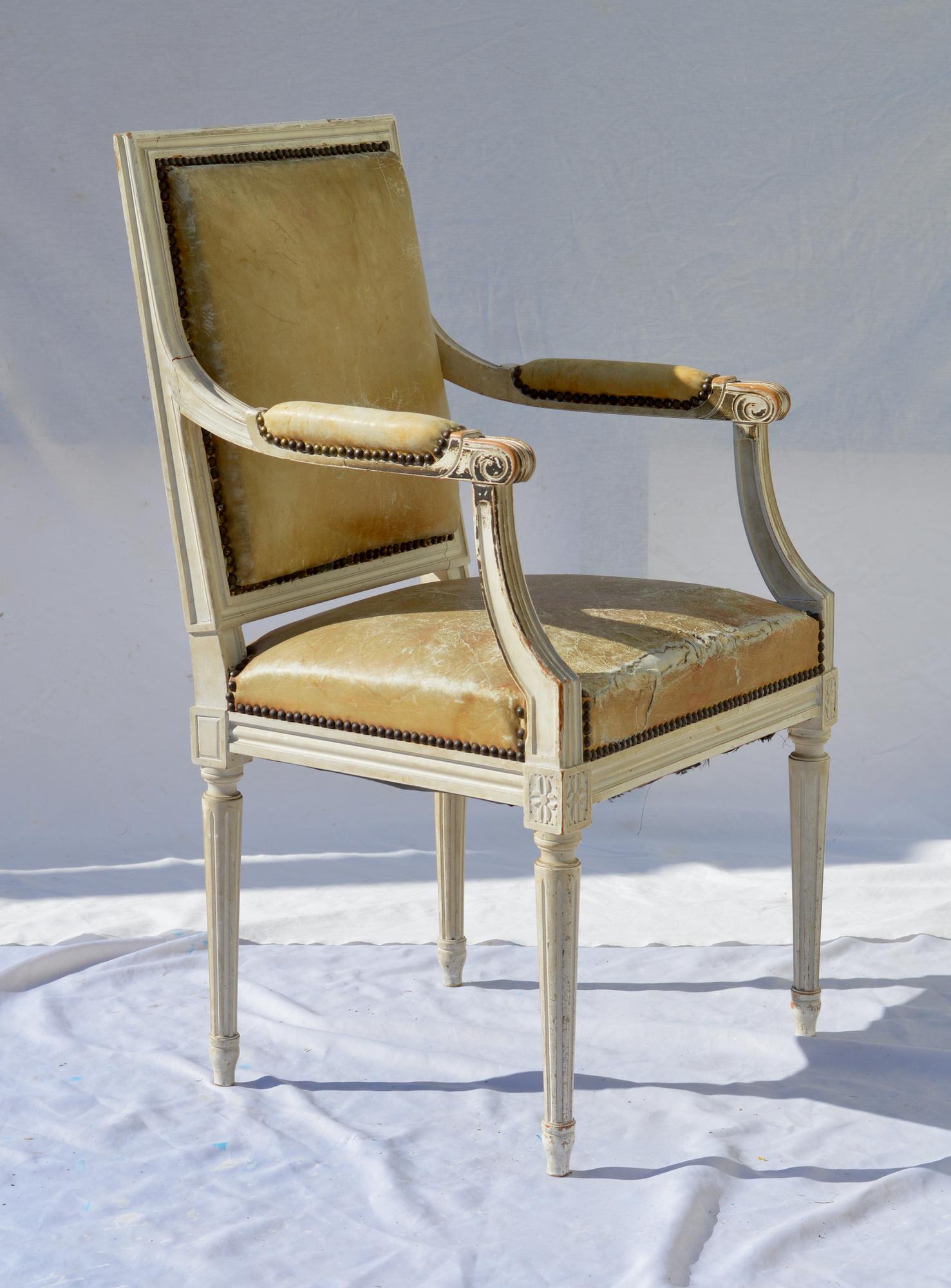 Wonderfully aged Louis XVI armchair in perfect eggshell paint and worn leather. The Classic French armchair performs well as a daily desk chair or will get lots of looks as a hall chair in a tight foyer. Very comfy and regardless of the tears in