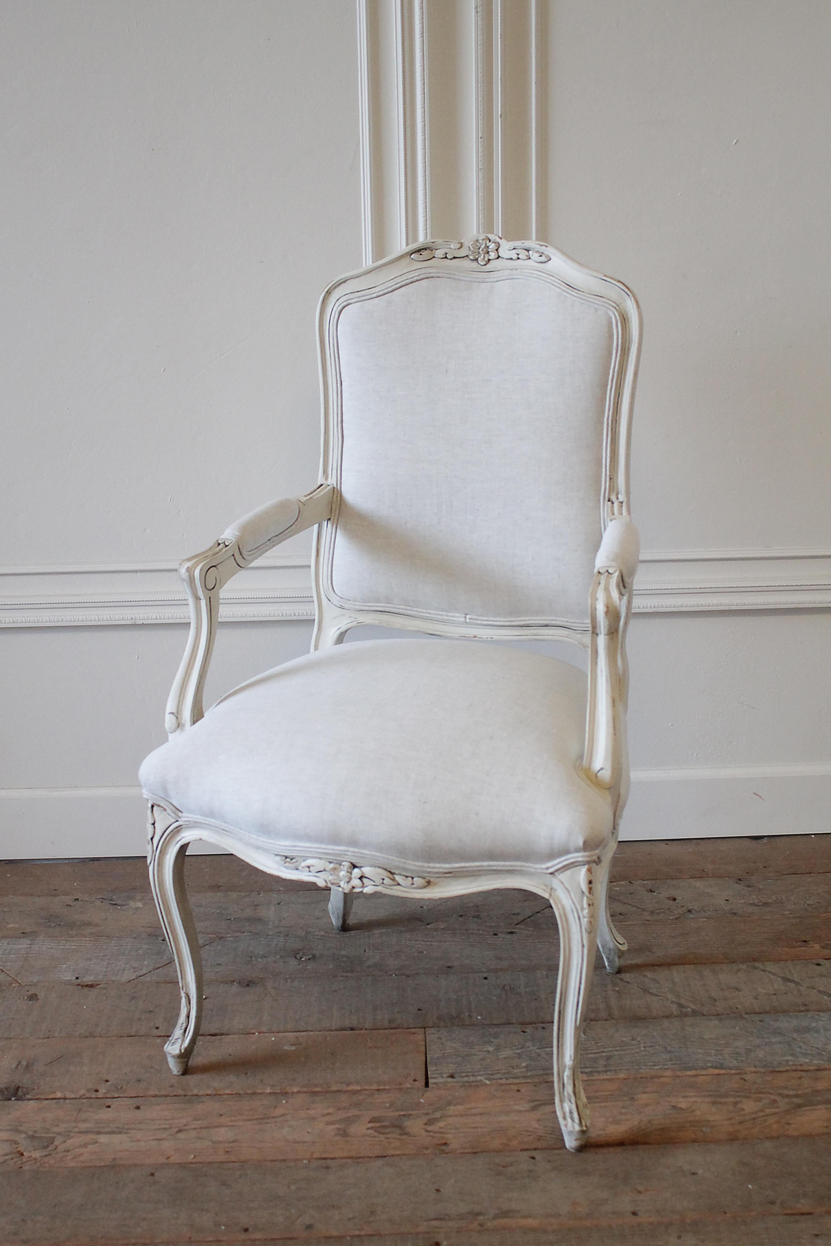 Painted French provincial style chair and ottoman upholstered in Belgian linen
painted in our oyster white finish with subtle distressed edges and finished with an antique glaze, give this set an aged patina. Subtle carvings on the inside backs,