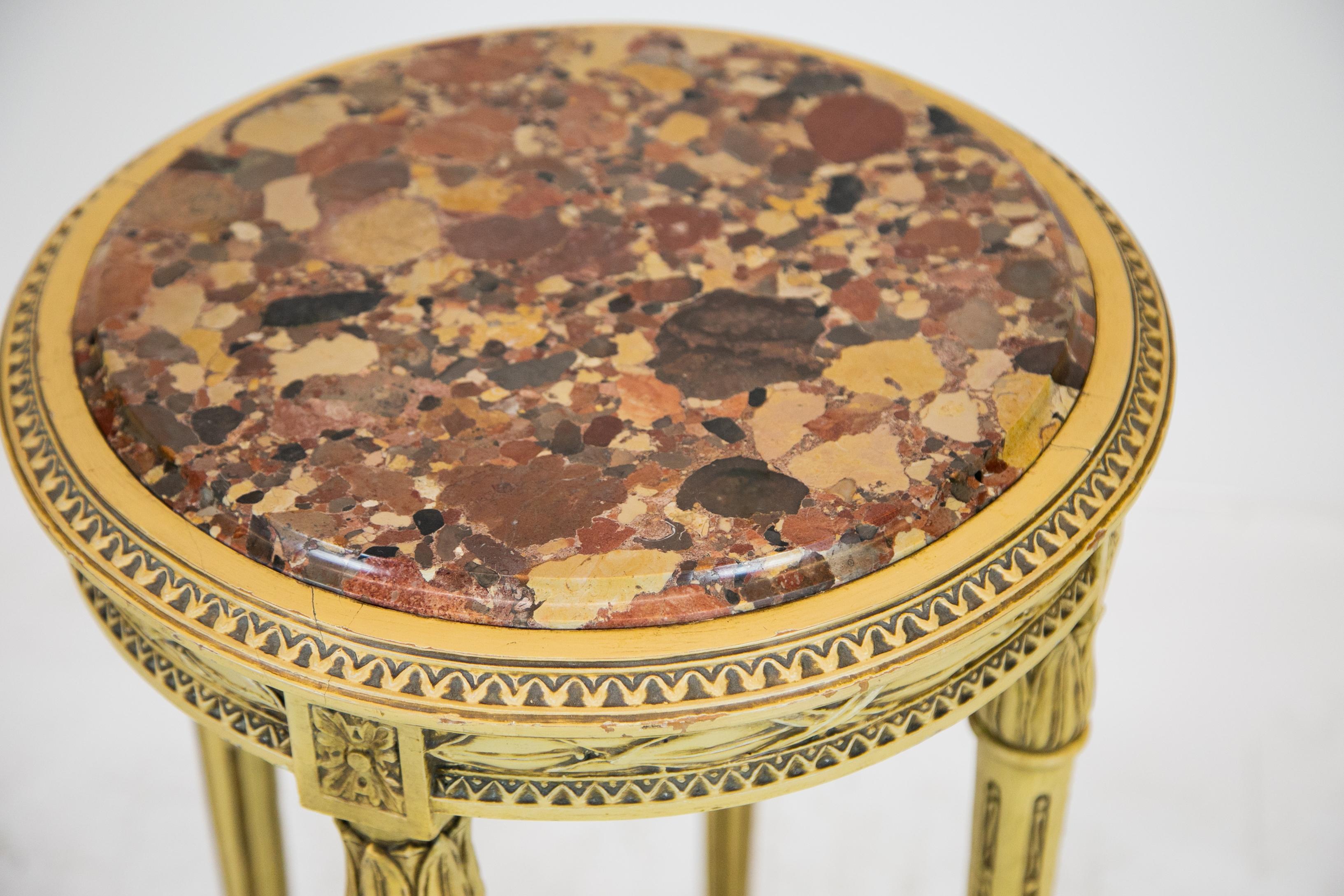 Painted French round marble-top table, with foliate decorated apron above fluted tapered legs connected with 'X' stretcher.