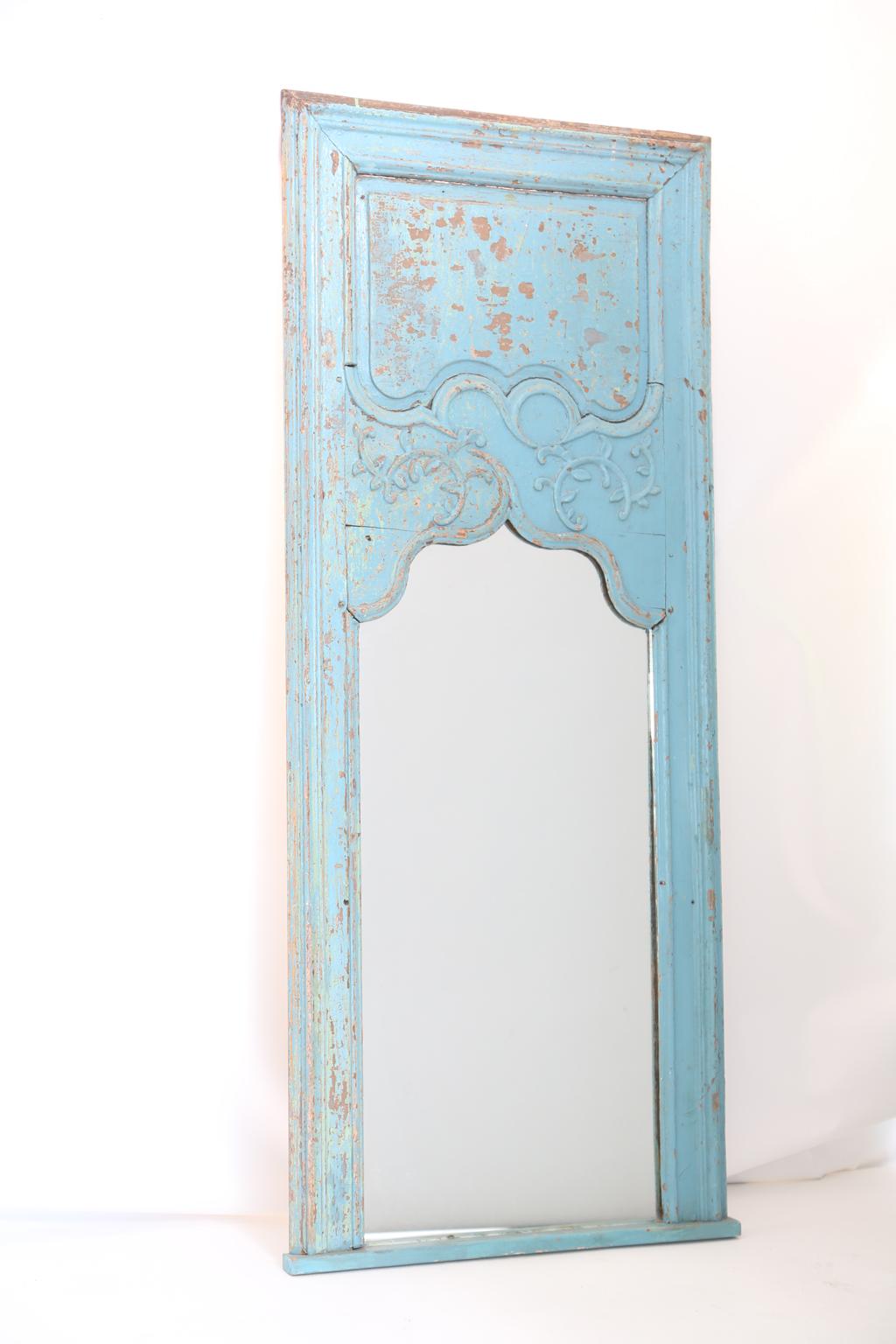 Painted Rococo trumeau mirror, having a painted finish showing desirable natural wear, its raised and fielded frame, surrounding foliate scrolls and a shaped mirrorplate. 

Stock ID: D2498.
