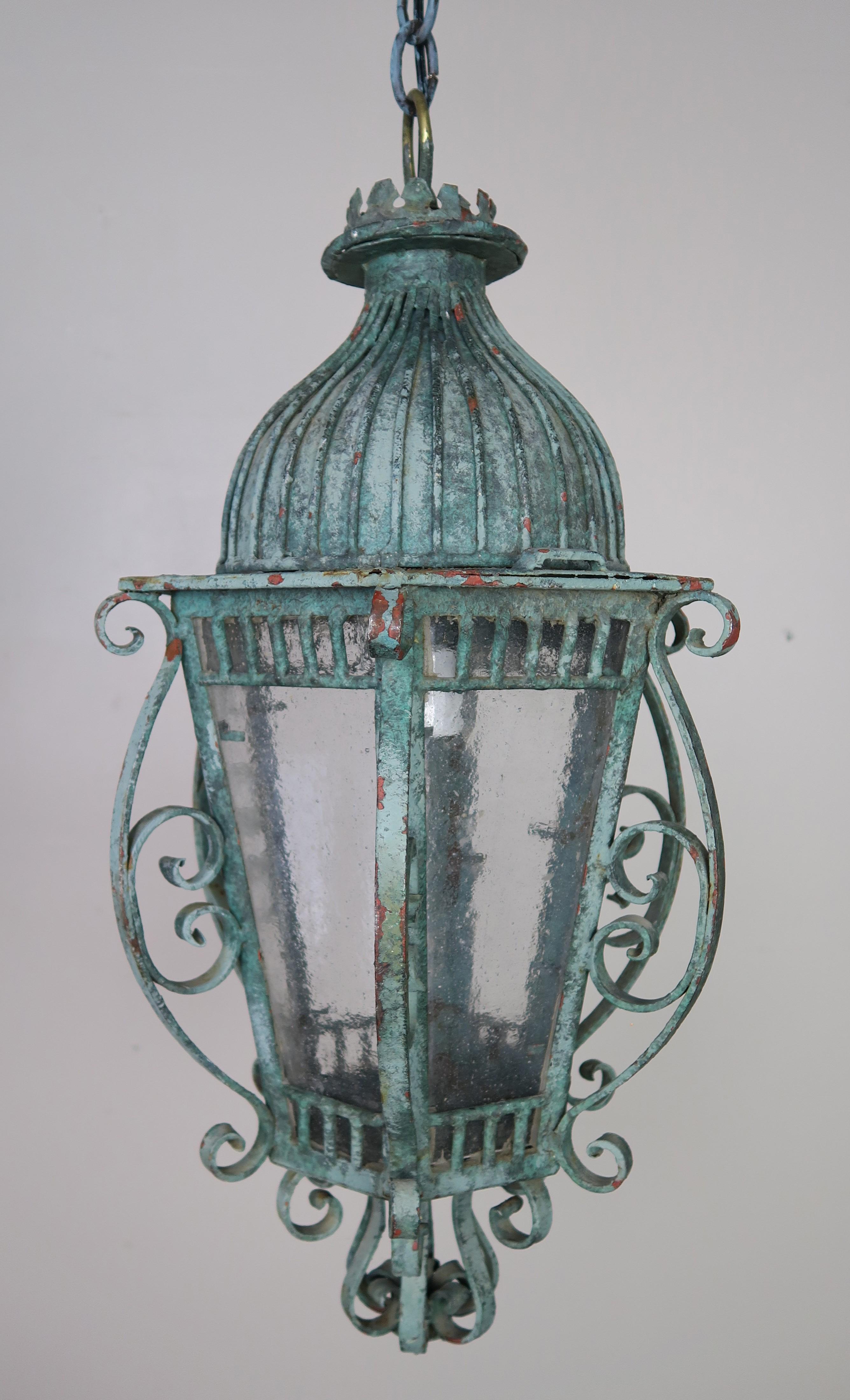 French wrought iron painted dome top lantern in a soft green coloration. The paint is beautifully worn from years of use. This six sided fixture has soft pebbled textured glass. The lantern is newly rewired and includes chain and canopy. It is ready