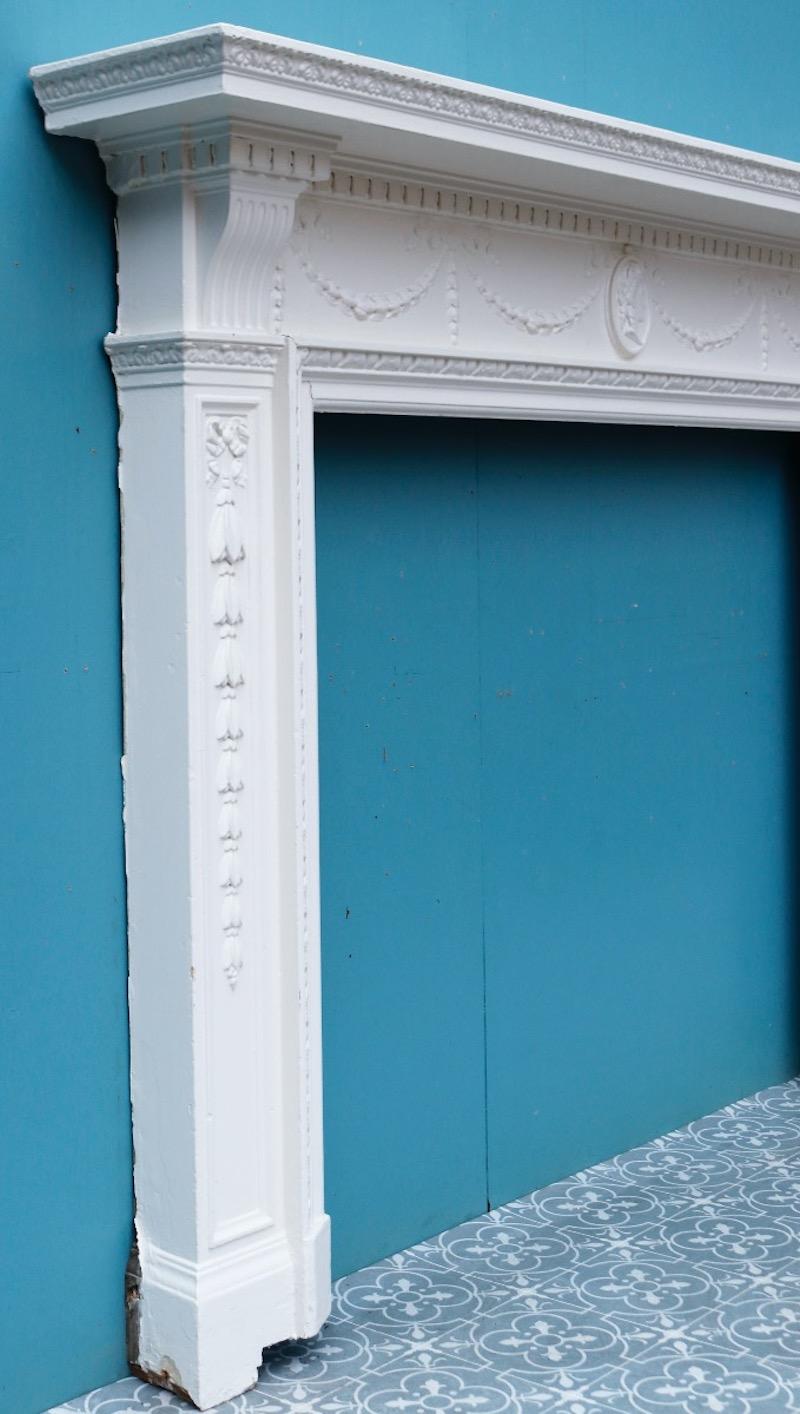 Ein bemalter Kamin im georgianischen Stil mit Kompositionsschwänzen und zentraler Kamee.
Zusätzliche Abmessungen 
Öffnungshöhe 103.5 cm
Öffnungsweite 122 cm
Breite zwischen den Außenseiten der Fußblöcke 166 cm.