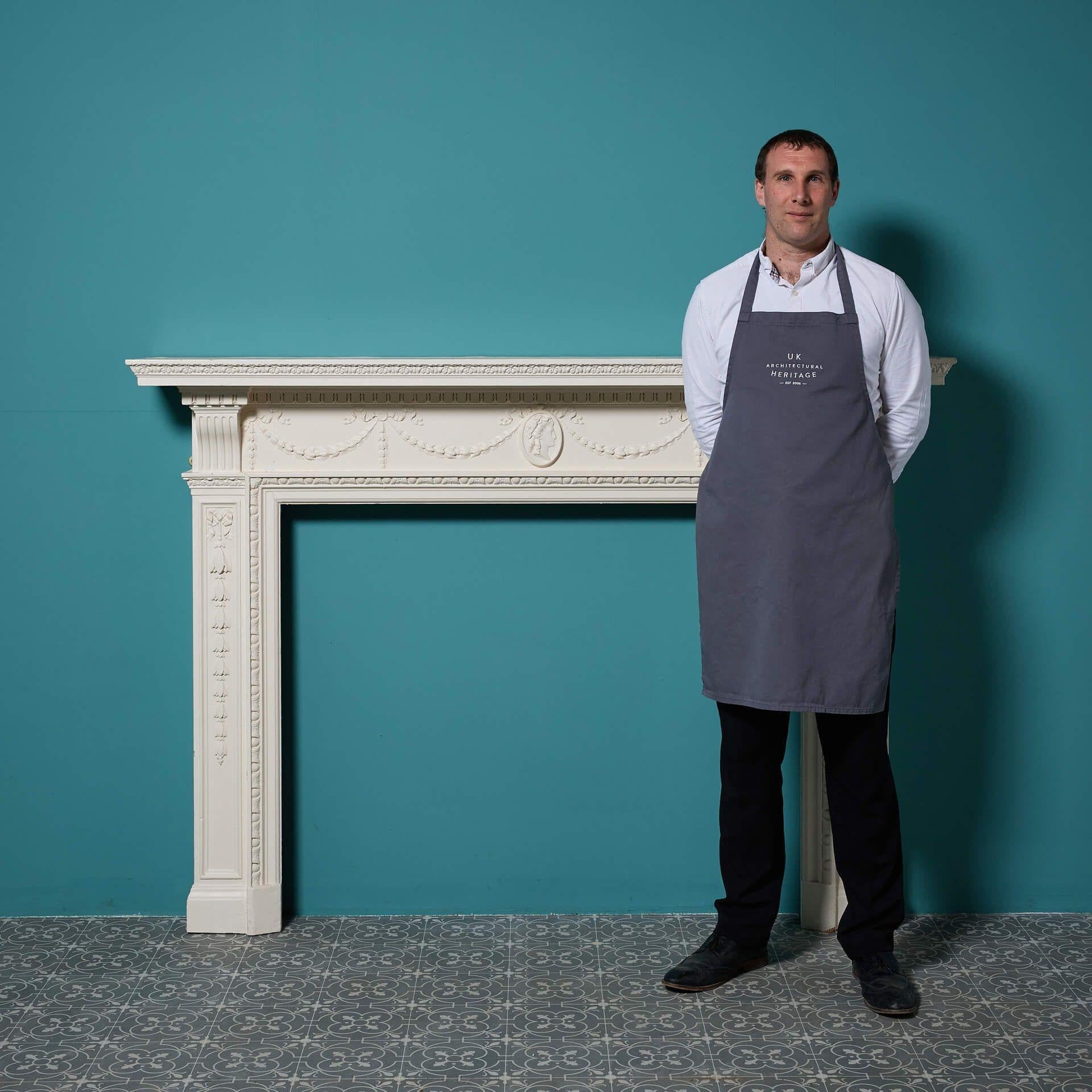 A painted Georgian style fire surround with composition swags and central cameo.
Additional Dimensions 
Opening height 103.5 cm
Opening width 122 cm
Width between outsides of the foot blocks 166 A painted Georgian style reclaimed fire surround with